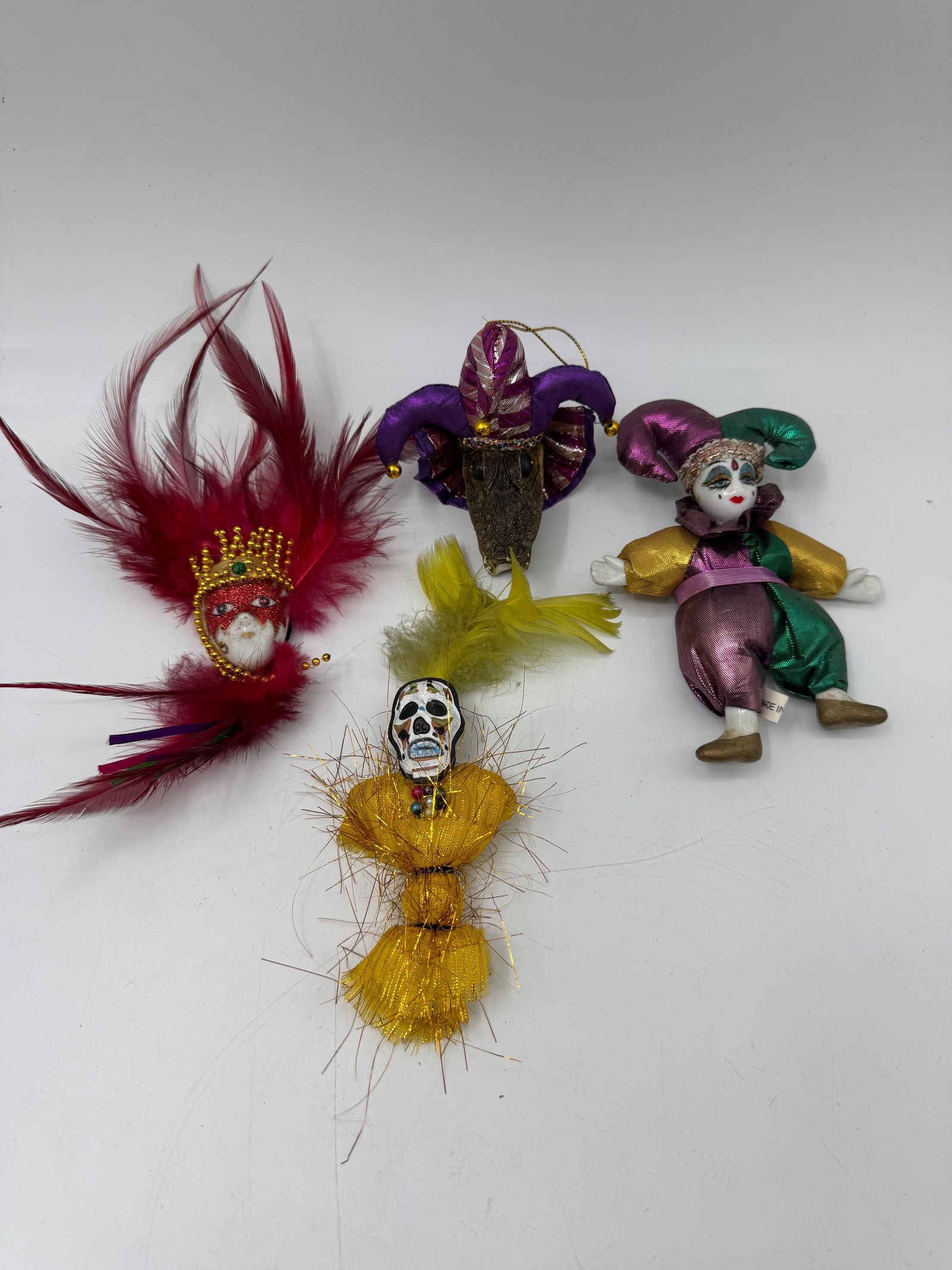 Mardi Gras Figural Magnets, Set of Four: Set of four figural magnets, likely souvenirs. Includes a feathered mask, two harlequin figures, and two figures with skull faces. Tallest measures approximately 5 inches.