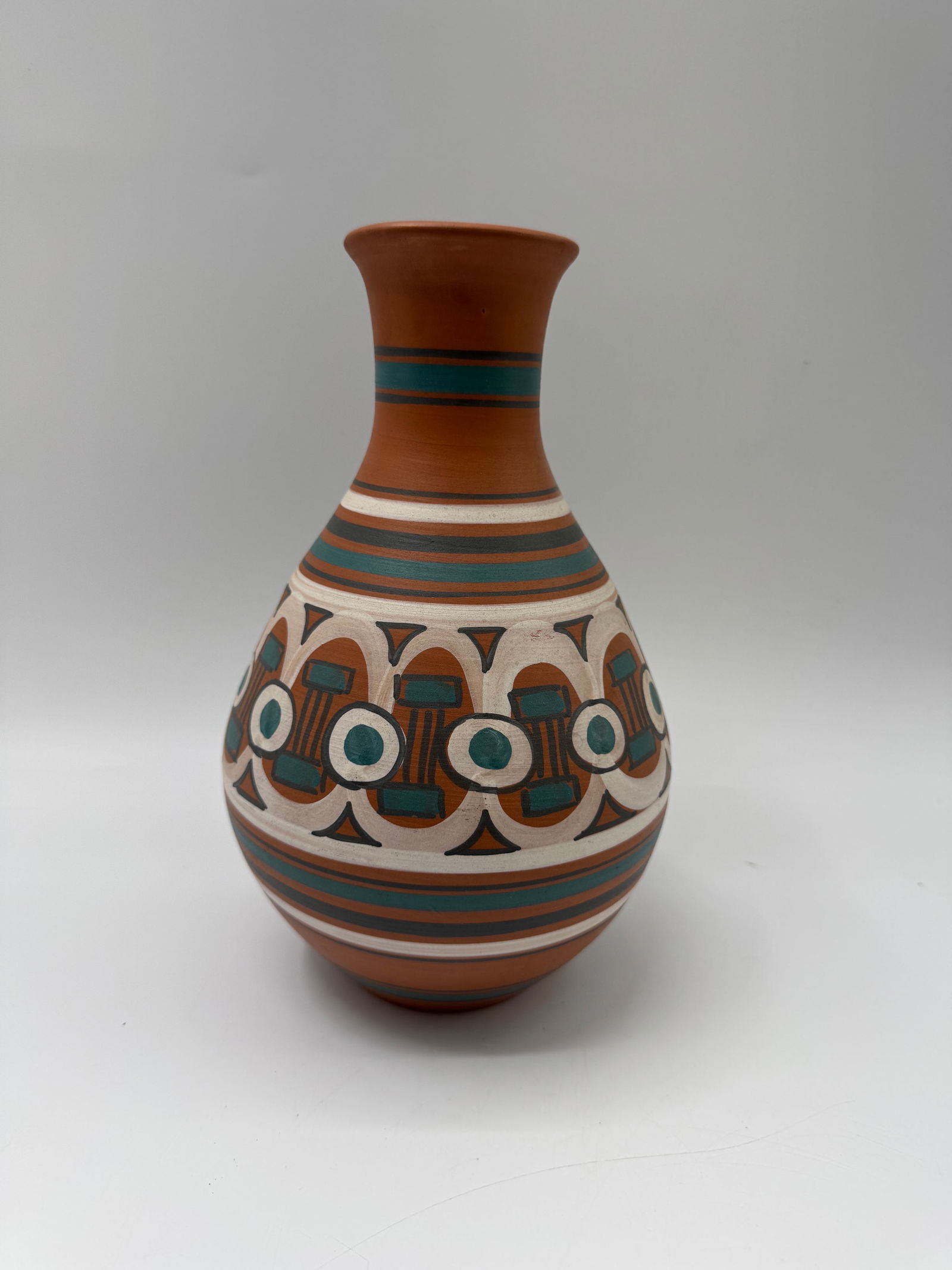 Hand Painted Pottery Vase: Hand painted pottery vase featuring geometric designs in brown, white, and teal. Measures approximately 10 x 6 inches.