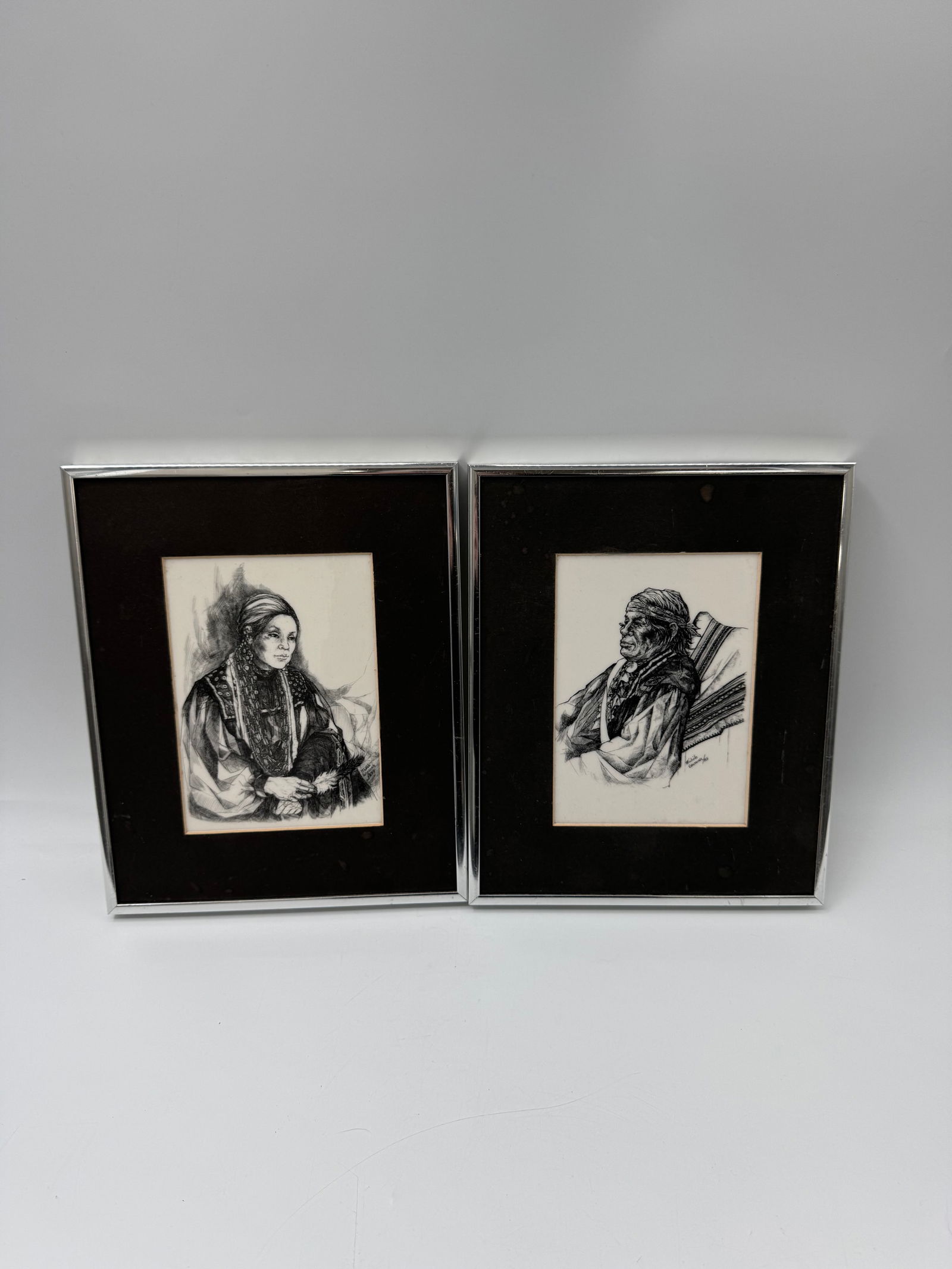 Pair of Native American Framed Portraits - Michelle Gauthier: Pair of framed ink portraits on paper. Each depicts a bust-length portrait of a person in traditional dress. Each measures approximately 11 x 9 inches framed. Information on the sitters is affixed to