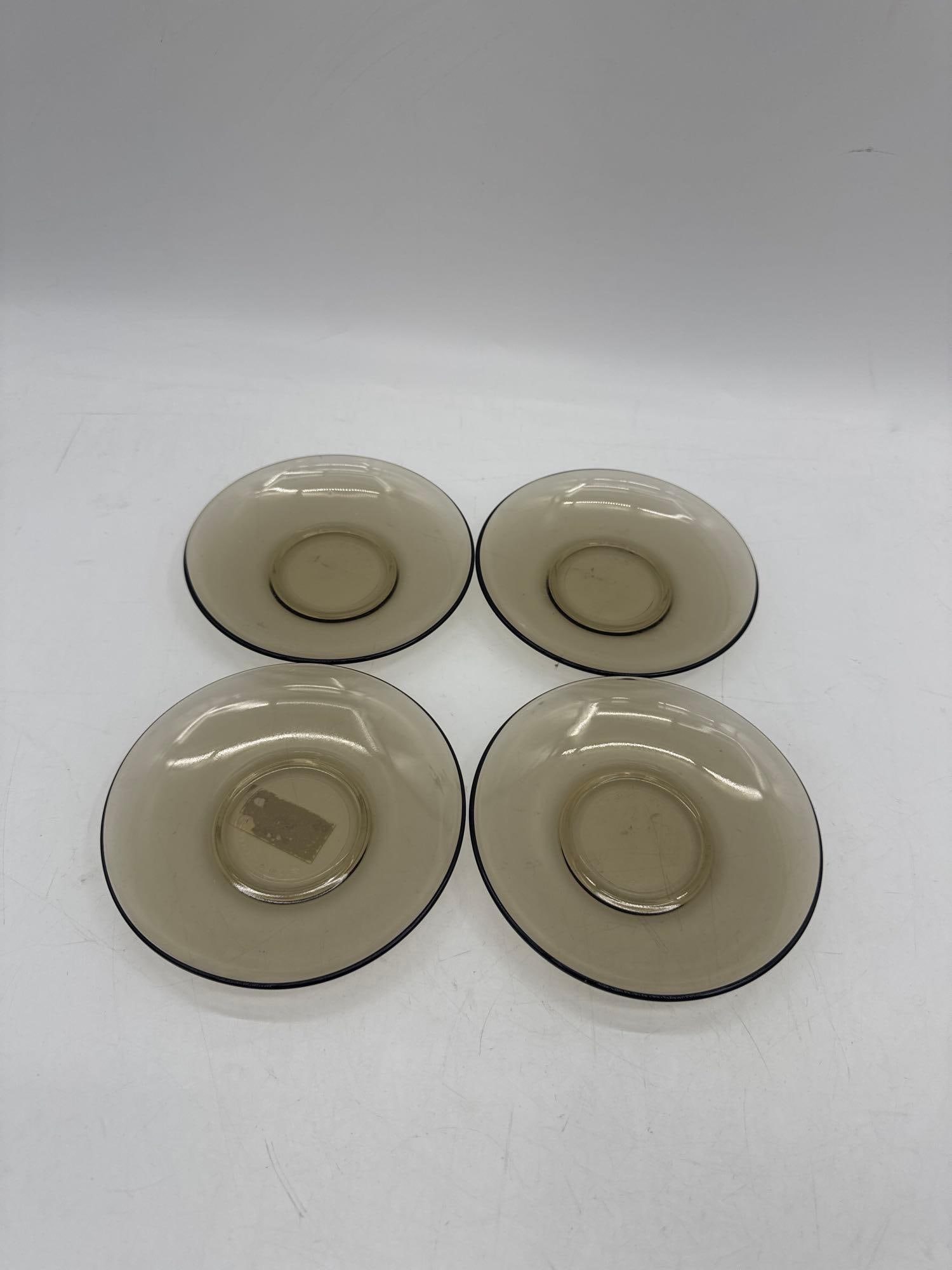 Set of 4 Vintage Amber Glass Saucers:  A set of four mid-century style amber glass saucers. Each features a simple, transparent design with a central well, perfect for pairing with matching teacups or as small serving dishes.