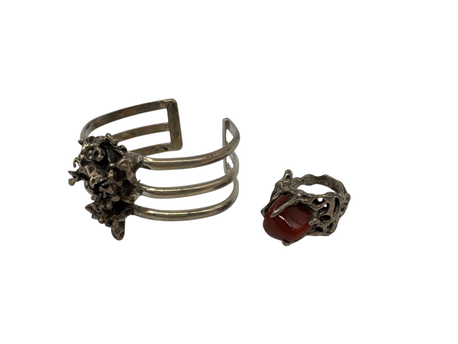 Gloria Landsman Pierce Carnelian and Sterling Silver Jewelry Set: This handcrafted jewelry set was created by artist Gloria Landsman Pierce and features a bold carnelian stone paired with sculptural sterling silver settings. The set includes a cuff bracelet composed