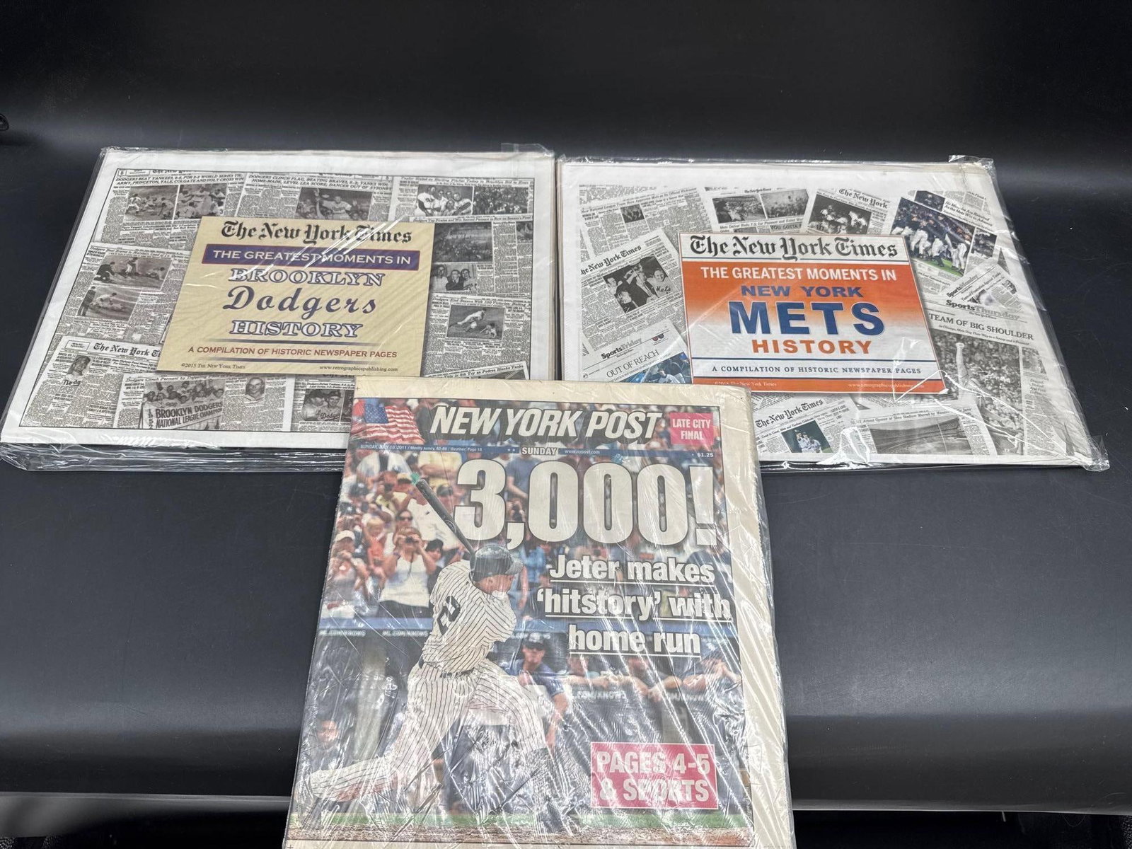 Collection of New York Sports Newspaper Reprints & Memorabilia: Group of three framed and wrapped sports memorabilia items, including:New York Post cover celebrating Derek Jeter’s 3,000th hit (July 2011).The New York Times “Greatest Moments