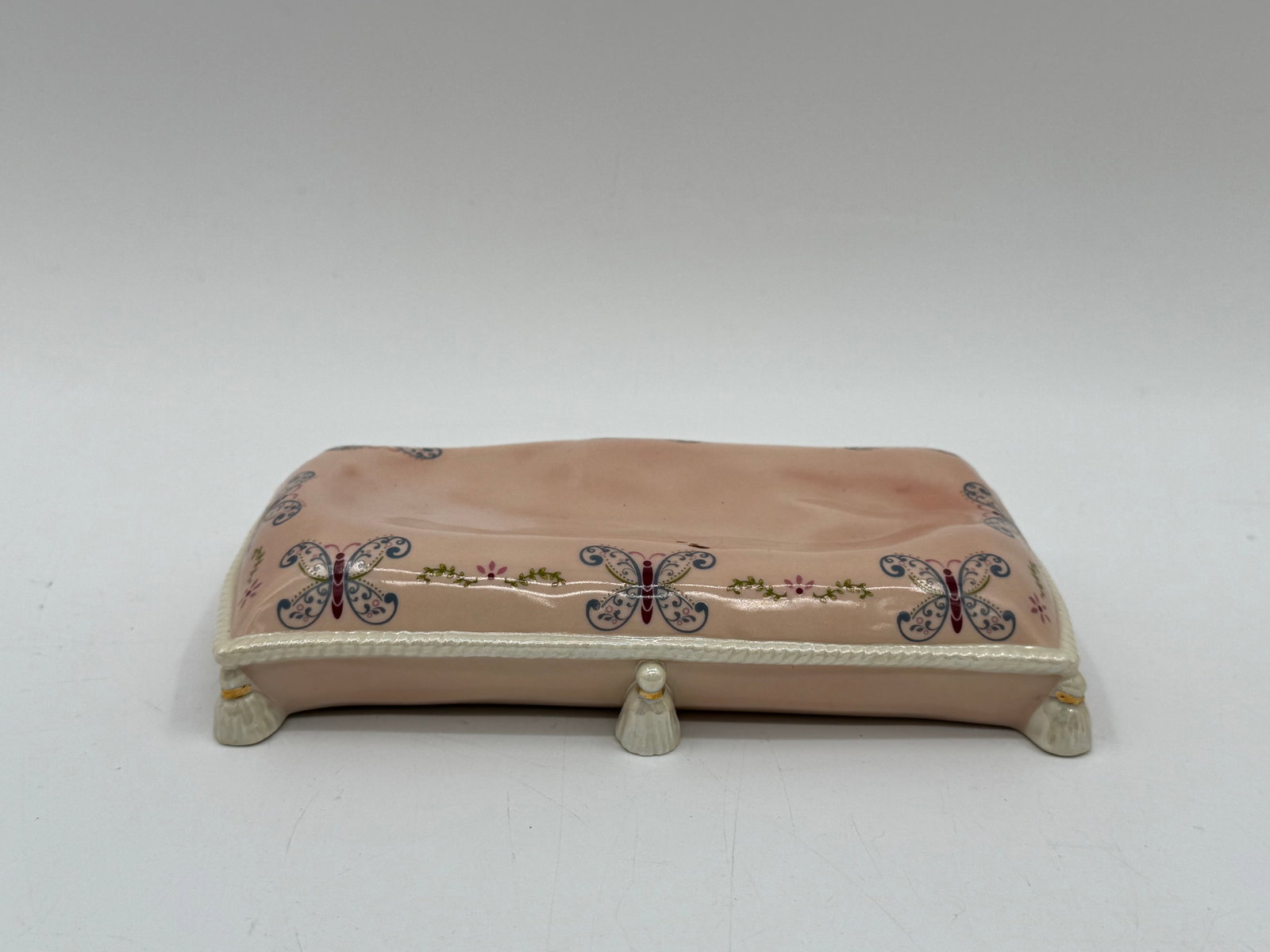 Lenox Lavonne Trinket Box: Lenox Lavonne trinket box. Features a pink glazed finish with butterfly and floral decoration. Marked on the underside. Measures approximately 8 x 4 inches.