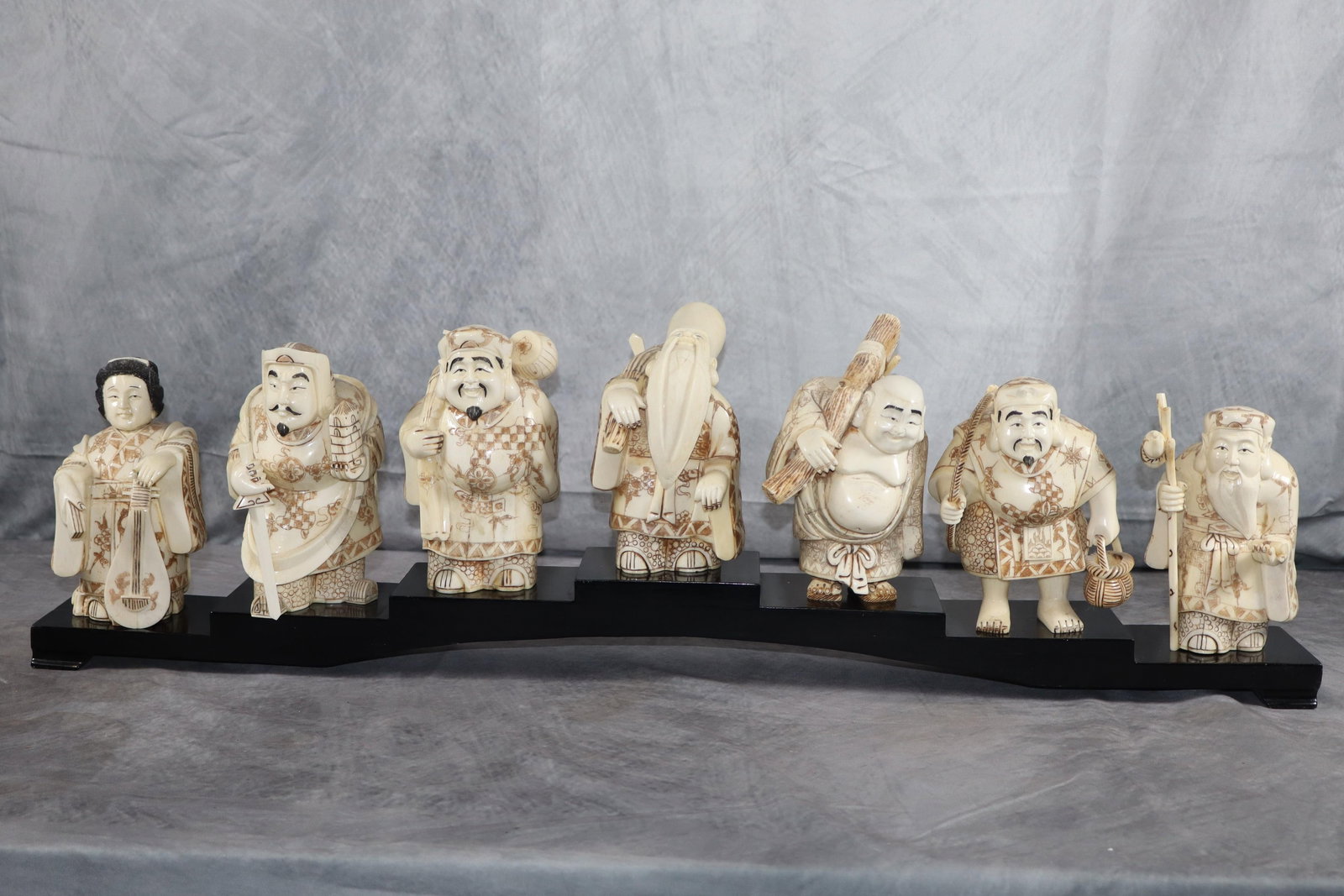 The Seven Lucky Gods, Shichifukujin,: This is a collection of seven figurines representing the Seven Lucky Gods of Japanese mythology. Each figure appears to be intricately carved, likely from a material resembling ivory or resin, and is