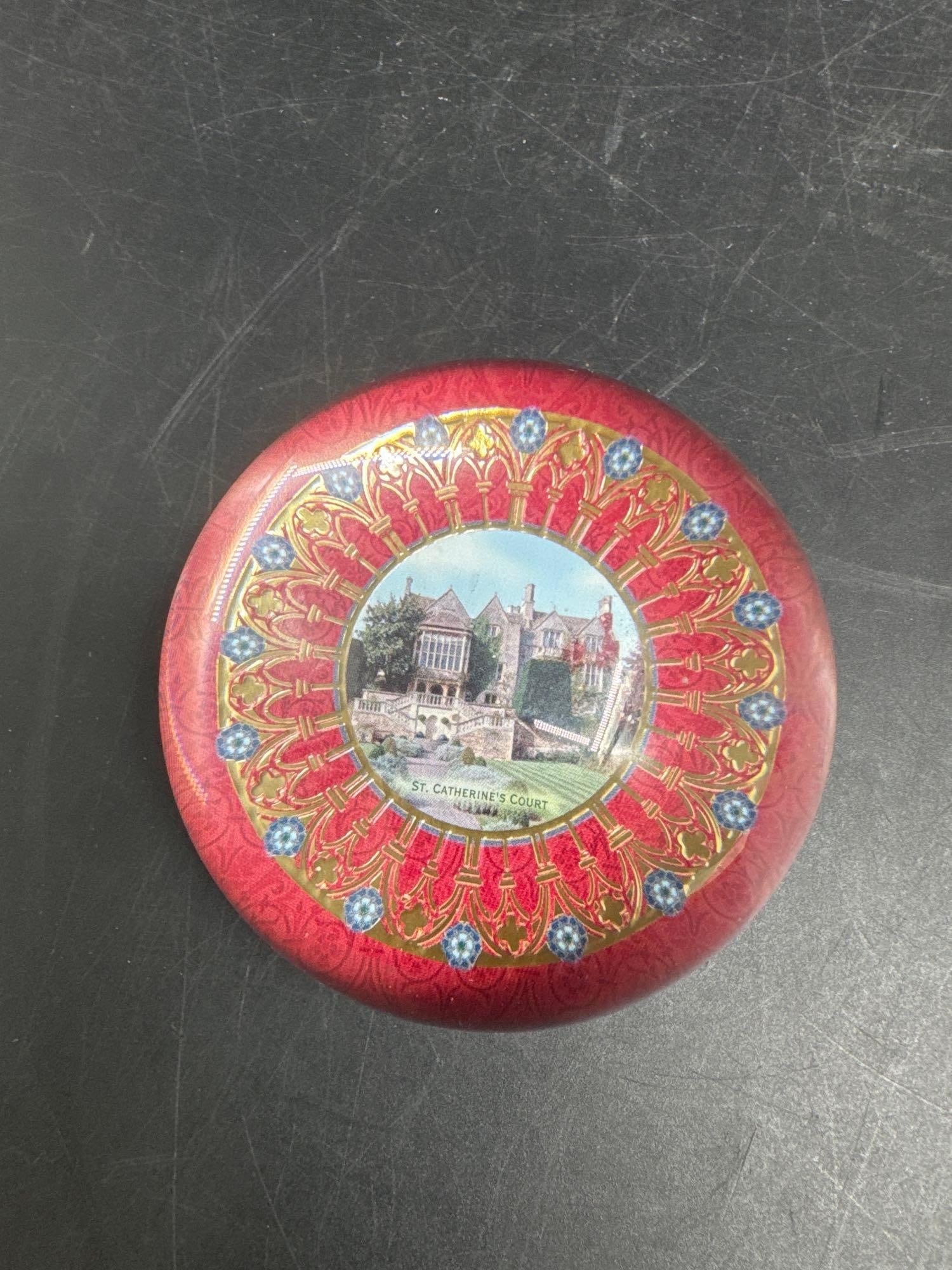 Jane Seymour Crystal Paperweight – St. Catherine’s Court: Limited edition crystal paperweight featuring an ornate red and gold design with an image of St. Catherine’s Court at the center. Designed by Jane Seymour, with crystal crafted in France and ima