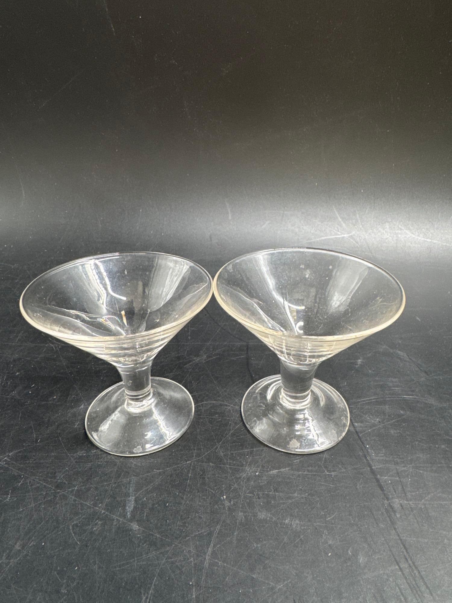 Pair of Vintage Clear Glass Cocktail Stems: Set of two vintage cocktail stem glasses with wide conical bowls and short pedestal bases. Classic mid-century barware design, perfect for serving martinis, cocktails, or desserts. Medium: Presse