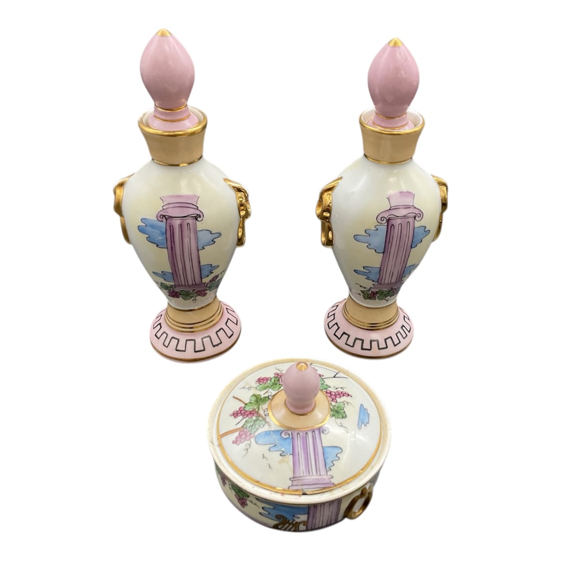 European Porcelain Vanity Set with Two Bottles and Lidded Trinket Bowl: This elegant European porcelain vanity set includes two matching decorative bottles and a coordinating lidded trinket bowl. The bottles feature finely painted classical motifs with pastel