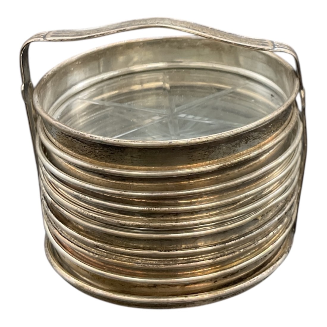 Set of Glass and Metal Coasters with Matching Holder: This coordinated set includes multiple round glass coasters framed in metal, accompanied by a matching stacked holder. Each coaster features a clear glass surface with subtle geometric detailing,