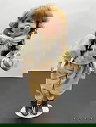 Porcelain Doll in Vintage Newsboy Outfit with Pigtails: This expressive porcelain doll has strawberry blonde hair styled in pigtails and an open-mouthed, singing or speaking expression. She wears a cream textured blouse with a large collar, a black velvet