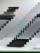 Large Rustic Metal and Glass cabinet: Oversized decorative cabinet with a distressed brown metal finish, vented top with floral cut-out motifs, and four glass panels. Hinged door allows access for placing a candle or decorative display.