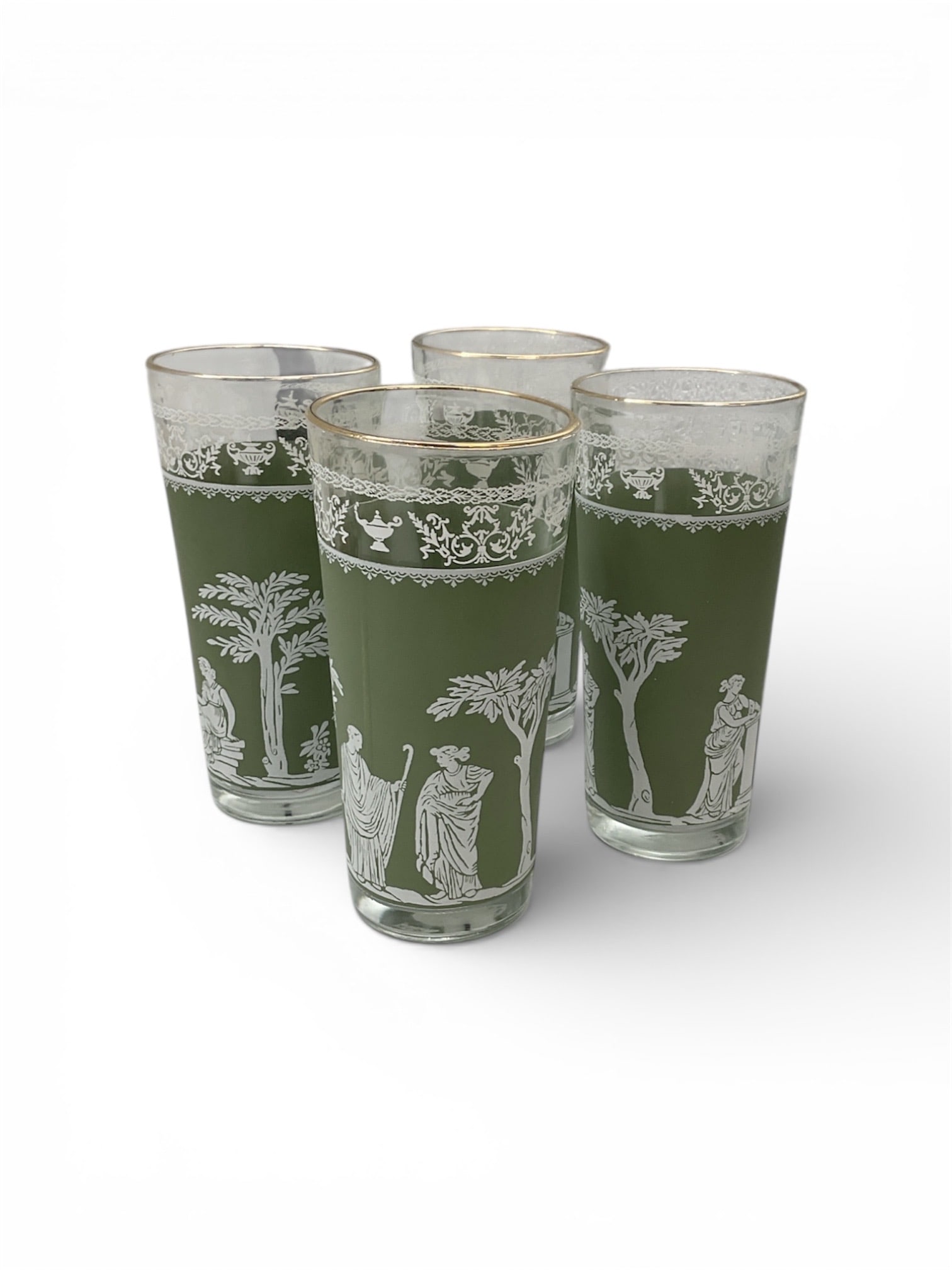 Set of Four Green Glass Tumblers with Classical White Enamel Decoration: This set of four green glass tumblers features white enamel decoration depicting classical figures, floral motifs, and architectural elements arranged in continuous friezes around each glass. The