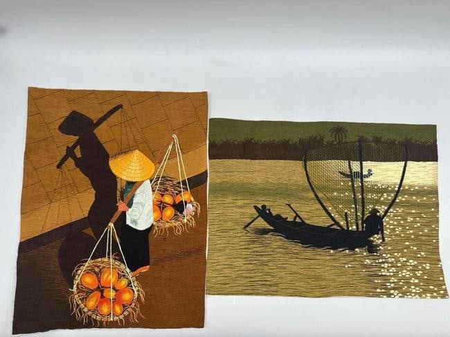 Vietnamese Village Life Scenes: Two textile artworks depicting traditional rural Vietnamese life. The top shows a woman carrying baskets of fruit with a dramatic shadow cast on the tiled street; the bottom features a fisherman casti
