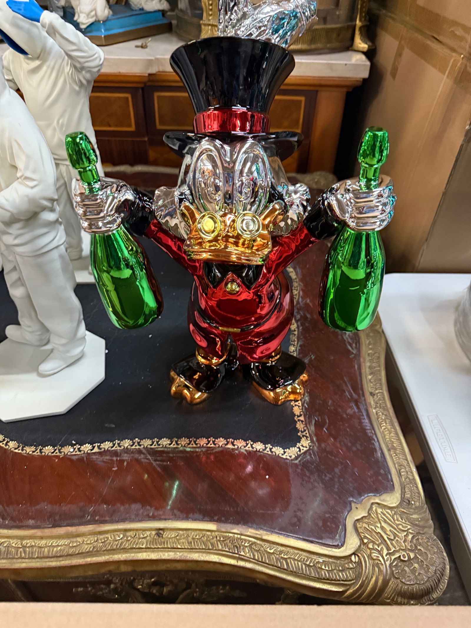 Luxury Pop Art: Red Chrome Scrooge McDuck Sculpture Holding Champagne Bottles - Alec Monopoly: Up for auction is a stunning, high-quality pop art sculpture of the iconic Disney character Scrooge McDuck, often associated with artists