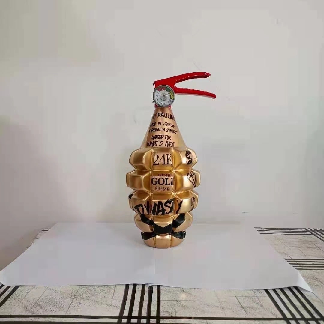 Unique "Pauli Dynasty" 24K Gold Grenade Art Sculpture - "What's Next" Modern Collectible: Description: This is a unique, eye-catching art piece in the form of a gold-colored grenade or vintage fire extinguisher, featuring bold text that reads "Pauli", "What's Next",