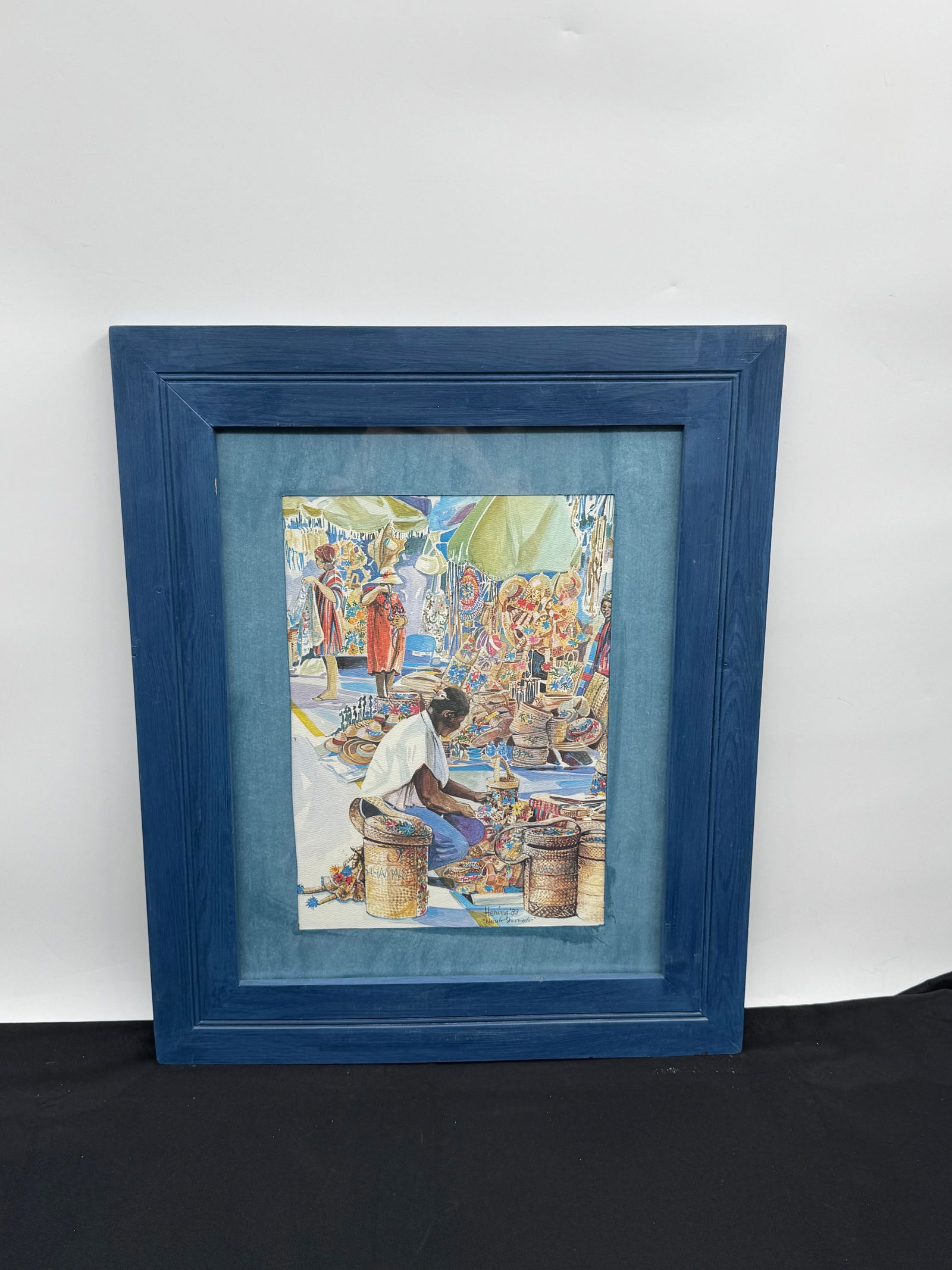 "Nassau Showmarket" by Hering: Watercolor painting by Hering, dated '83, depicting a scene at the Nassau Straw Market. Signed lower right. Framed and matted.Dimensions: 21 x 25 inches (framed).