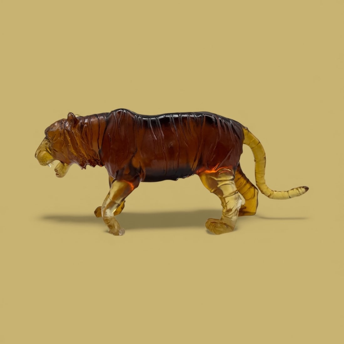 Amber Glass Tiger Figurine, Pate De Verre: Amber glass tiger figurine, measuring H:7in L:17in W:4in. Detailed carving and coloration. Pate De Verre