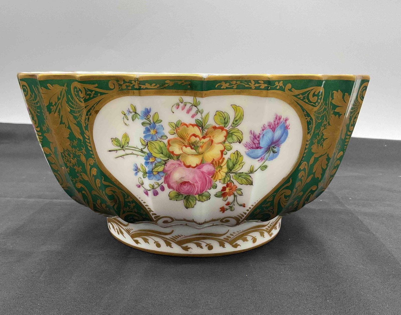 RARE Swansea Hand-Painted Floral and Gilt Scalloped Porcelain Bowl: Elegant scalloped porcelain bowl with rich green panels, hand-painted floral sprays, and ornate gilt accents. Features alternating floral cartouches and intricate gold scrollwork. Likely European,