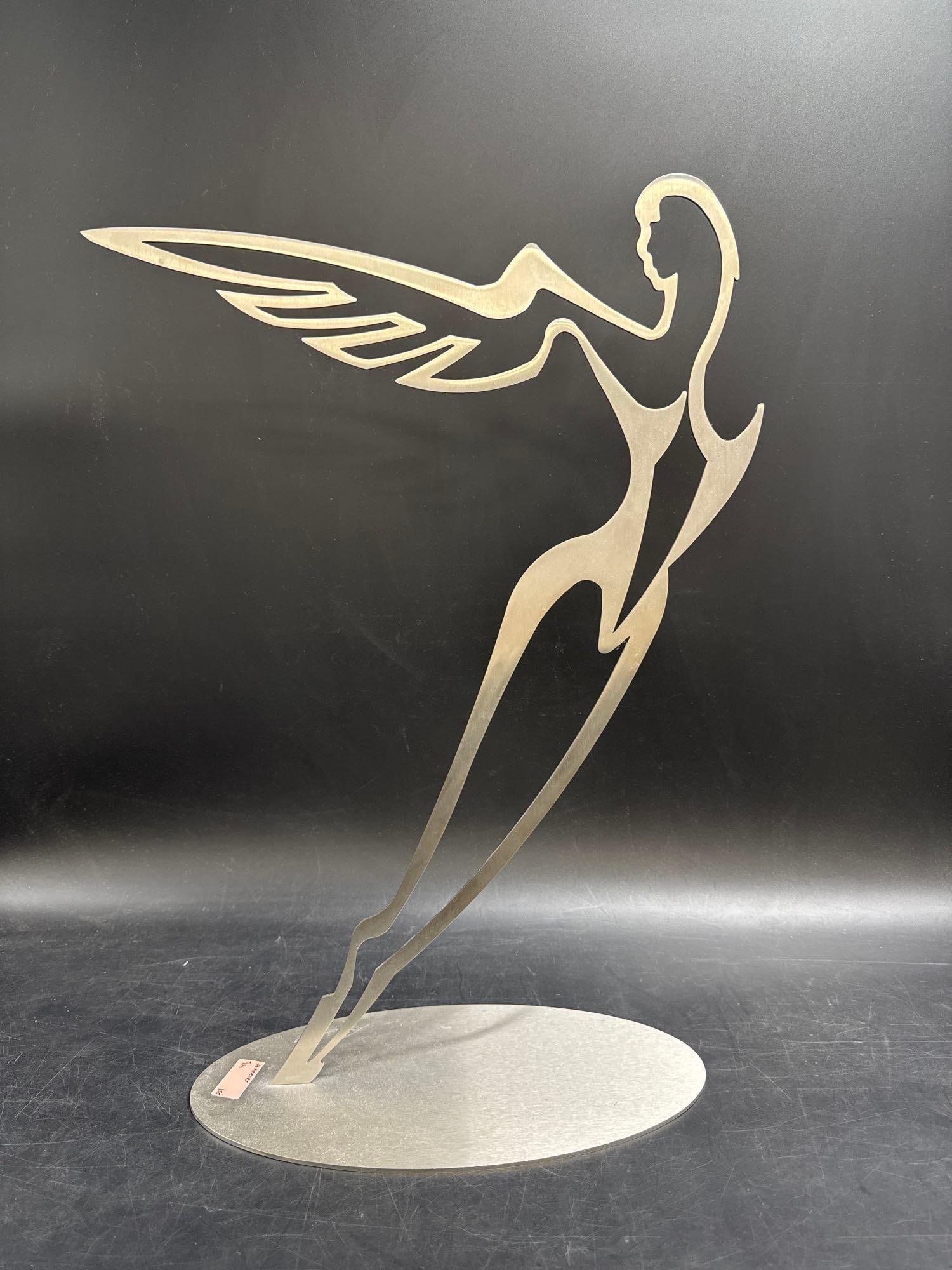RARE Alfred Gockel Heavens Wing - 53/95:  Modern abstract stainless steel sculpture depicting a stylized female figure in motion. Mounted on a circular black base. Signed "Kishel" and numbered 53/95.Medium: Stainless stee