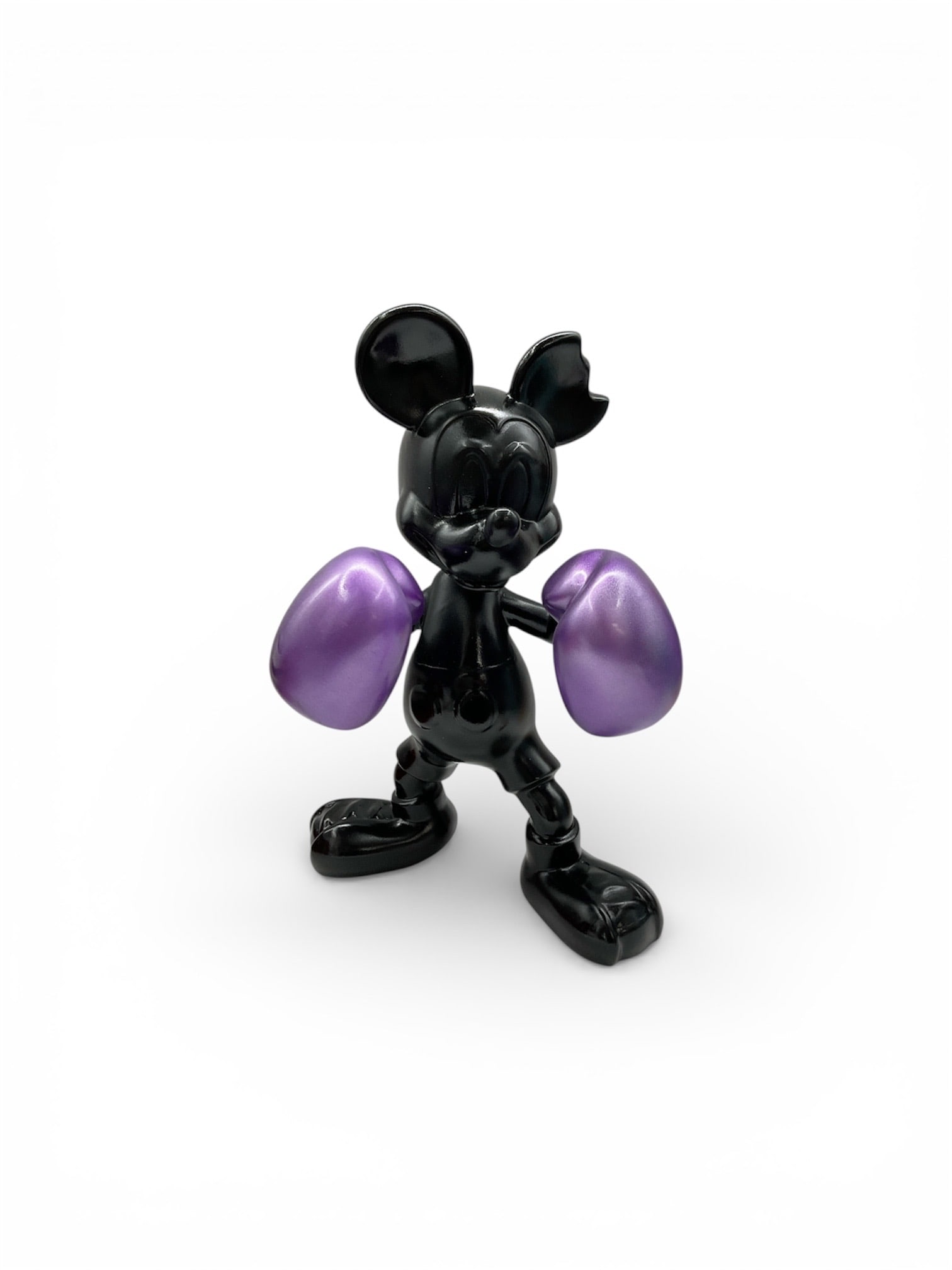 Contemporary Mickey Mouse Boxing Glove Sculpture in Black with Purple Gloves: This contemporary decorative sculpture depicts an iconic Mickey Mouse–style figure posed in a confident stance while wearing purple boxing gloves. Rendered in a high-gloss black finish, the