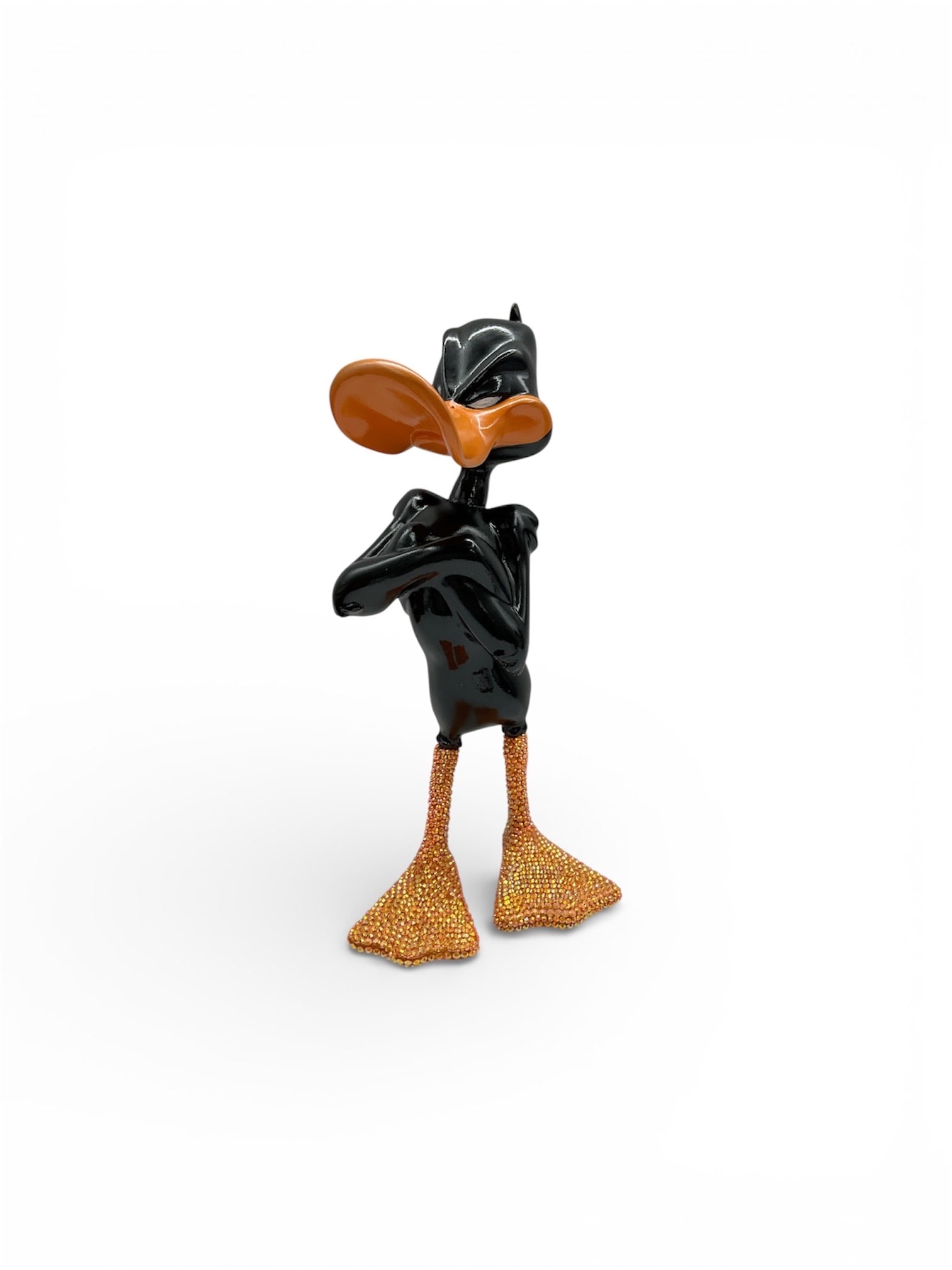 Contemporary Daffy Duck Sculpture with Orange Beak and Feet, Pop Art Style Figure: This contemporary decorative sculpture depicts a Daffy Duck–inspired figure standing confidently with crossed arms, rendered in a glossy black finish with vibra