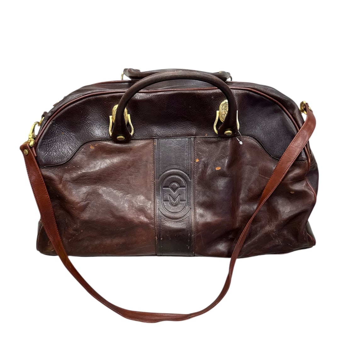 Marino Orlandi Italian Leather Duffel Bag with Shoulder Strap: This Marino Orlandi duffel bag is crafted from genuine leather and made in Italy, featuring a rich brown tone with a structured yet supple form. The bag is designed with dual top handles, a