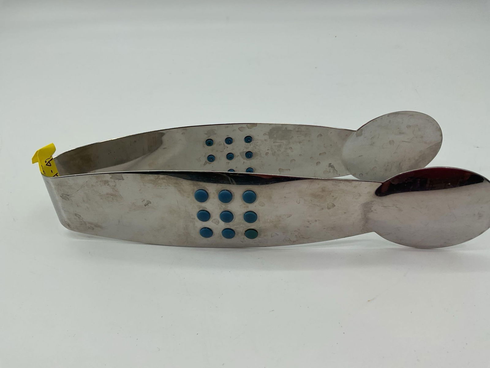 Modern Stainless Steel Tongs with Blue Grip Accents: Contemporary stainless steel tongs featuring blue raised dots on each side for grip and control. Flat spoon shaped ends provide a secure hold, suitable for serving or buffet use.Dimensions: Length