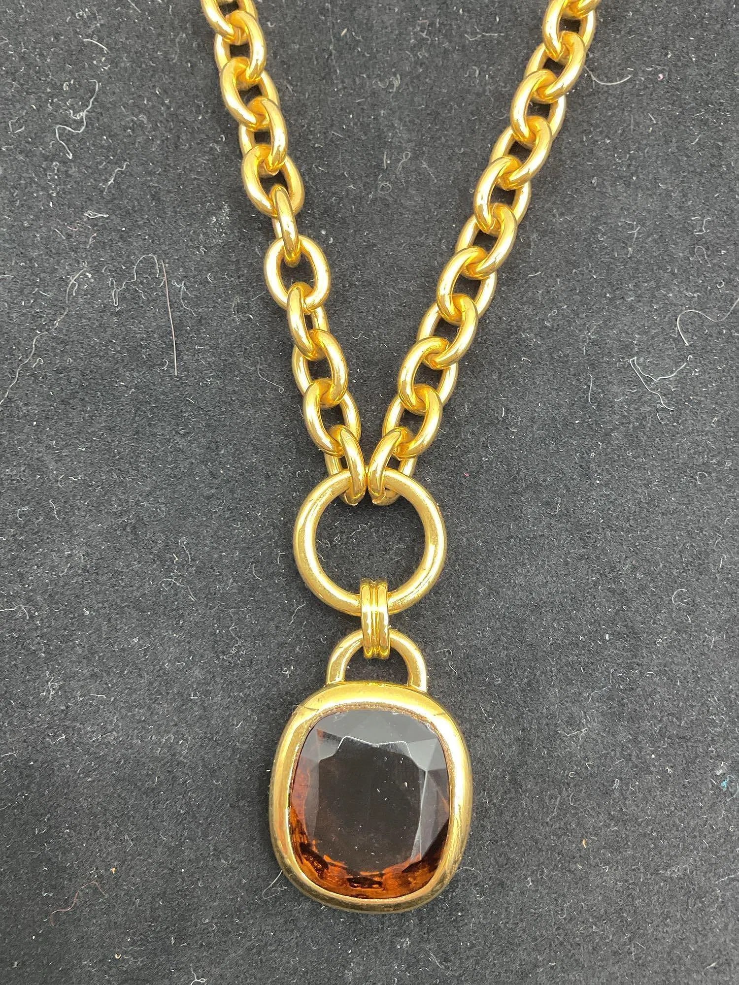 Gold Tone Chain Necklace with Amber-Colored Glass Pendant: Chunky gold tone chain necklace featuring a cushion-cut amber-colored glass pendant set in a rounded bezel frame.Dimensions: L34inMedium: Metal and glass