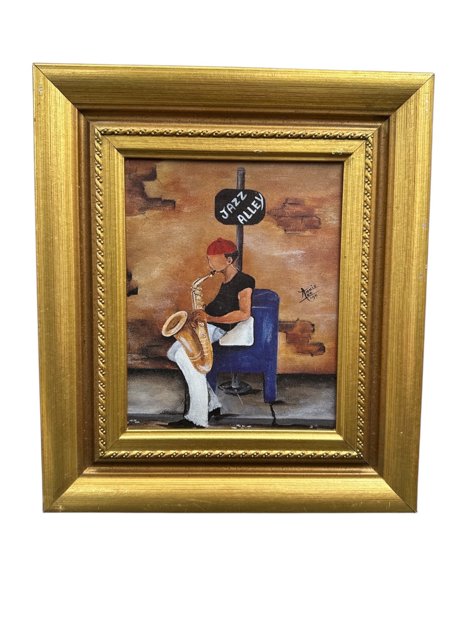 Annie Lee Folk Art Painting of Man Playing Saxophone Jazz Alley Scene: Folk art painting by Annie Lee depicting a man seated and playing a saxophone beneath a street sign reading Jazz Alley. Executed in the artist’s distinctive narrative style, the composition