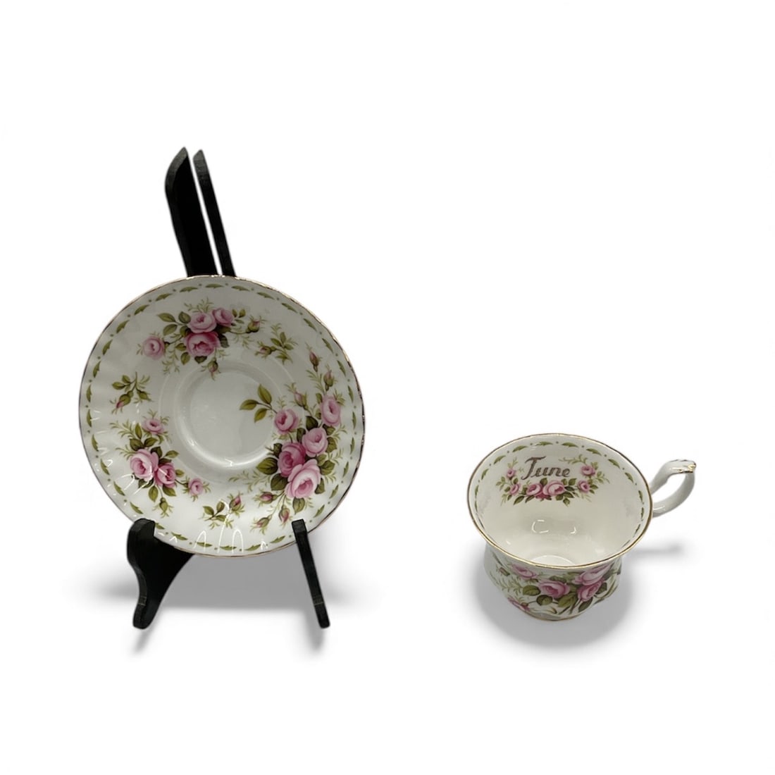 Royal Albert Floral Teacup and Saucer Set: Elegant Royal Albert bone china teacup and matching saucer decorated with soft pink rose bouquets and delicate green foliage. Features classic English floral styling with scalloped edges and subtle gi