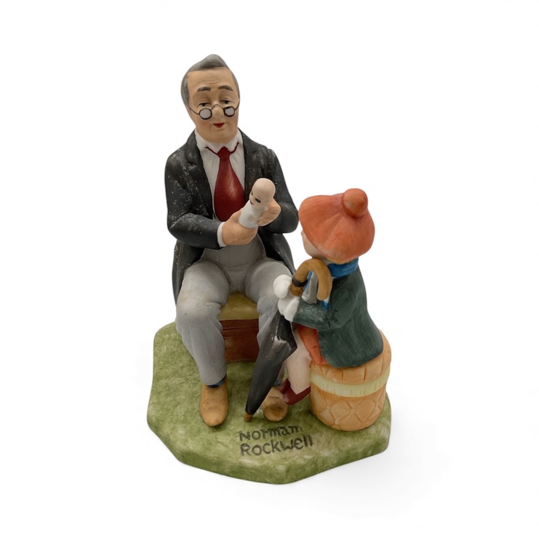 Norman Rockwell Figurine “Doctor and the Doll: Porcelain figurine from the Norman Rockwell Collection, depicting a kindly doctor examining a young girl’s doll. Warm colors and expressive hand-painted details capture the charm of Rockwell&rsq