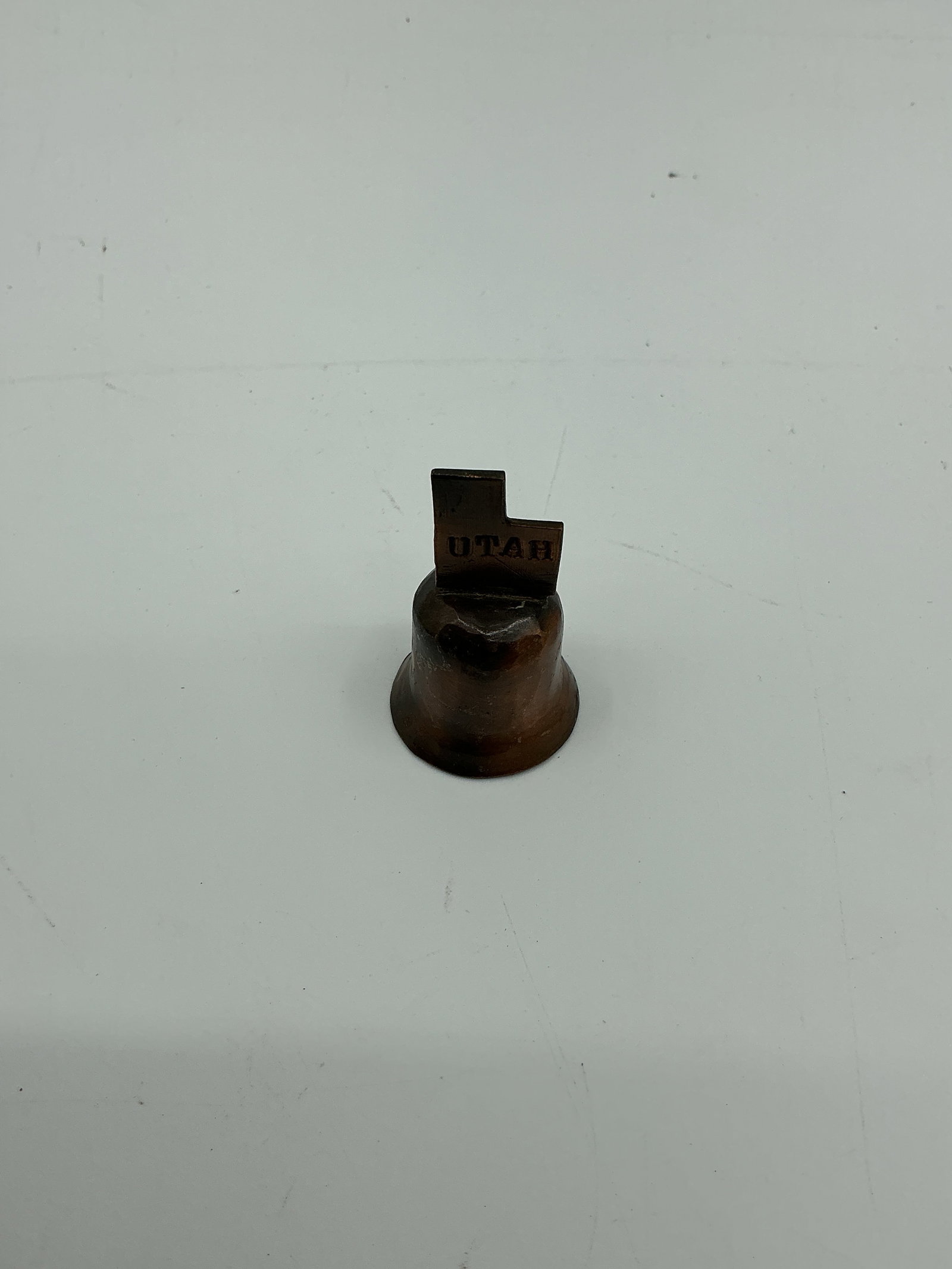 Small Souvenir Bell - Utah: Small souvenir bell, approximately 2 inches in height and 1 inch in diameter. Marked with 'UTAH'.