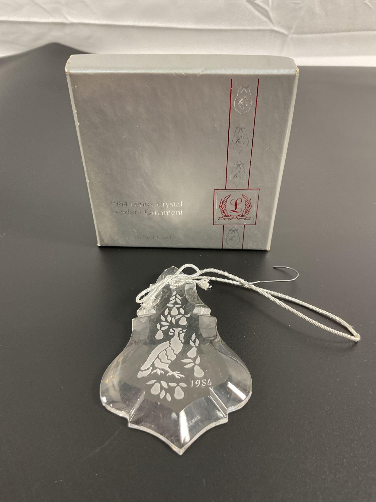 Lenox 1994 Crystal Bell Christmas Ornament in Gift Box: This is a Lenox crystal Christmas ornament, shaped like a bell, featuring etched floral patterns and the year "1994" engraved on the surface. It is housed in a red satin-lined silver gift box, indicat