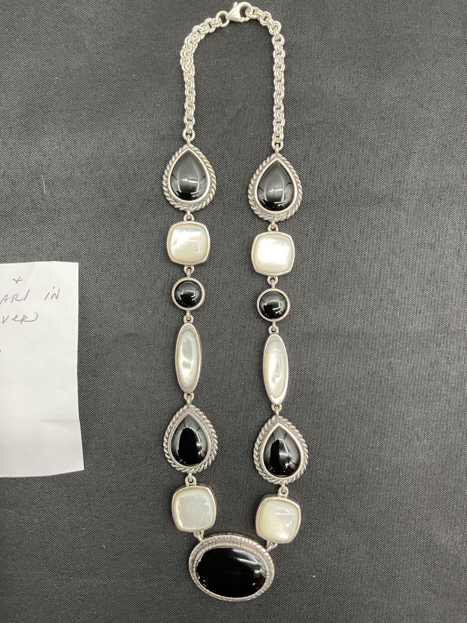 Sterling Silver Necklace with Black Onyx and Mother of Pearl: Bold and elegant sterling silver necklace featuring alternating polished black onyx and iridescent mother of pearl stones. The design includes teardrop, oval, and square cuts in a refined linked setti