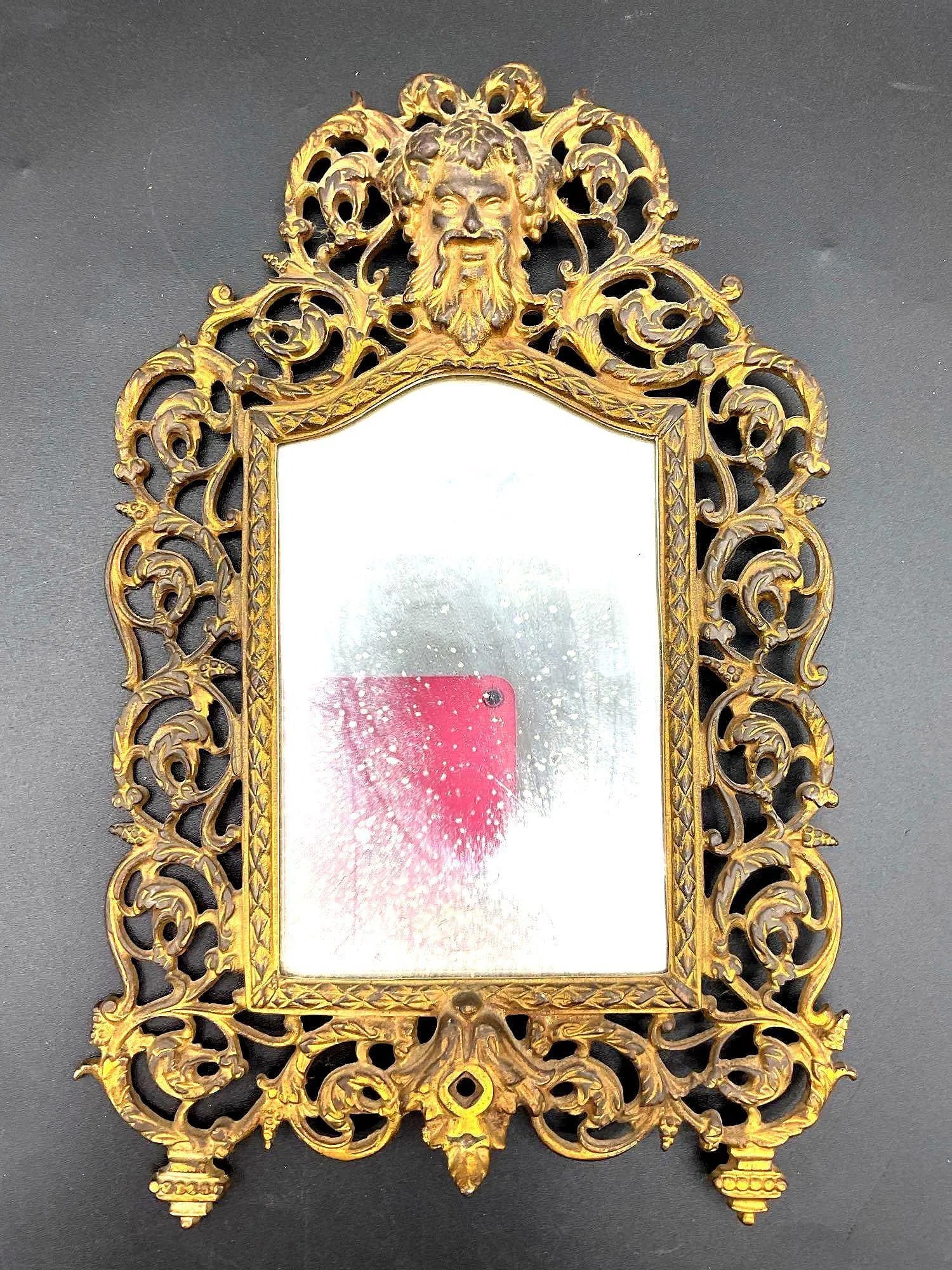 Antique Brass Vanity Mirror with Satyr Motif: This is an ornate antique tabletop vanity mirror featuring an intricately cast brass frame with elaborate floral and scrollwork details. The most striking element is the figure of a satyr or faun at t