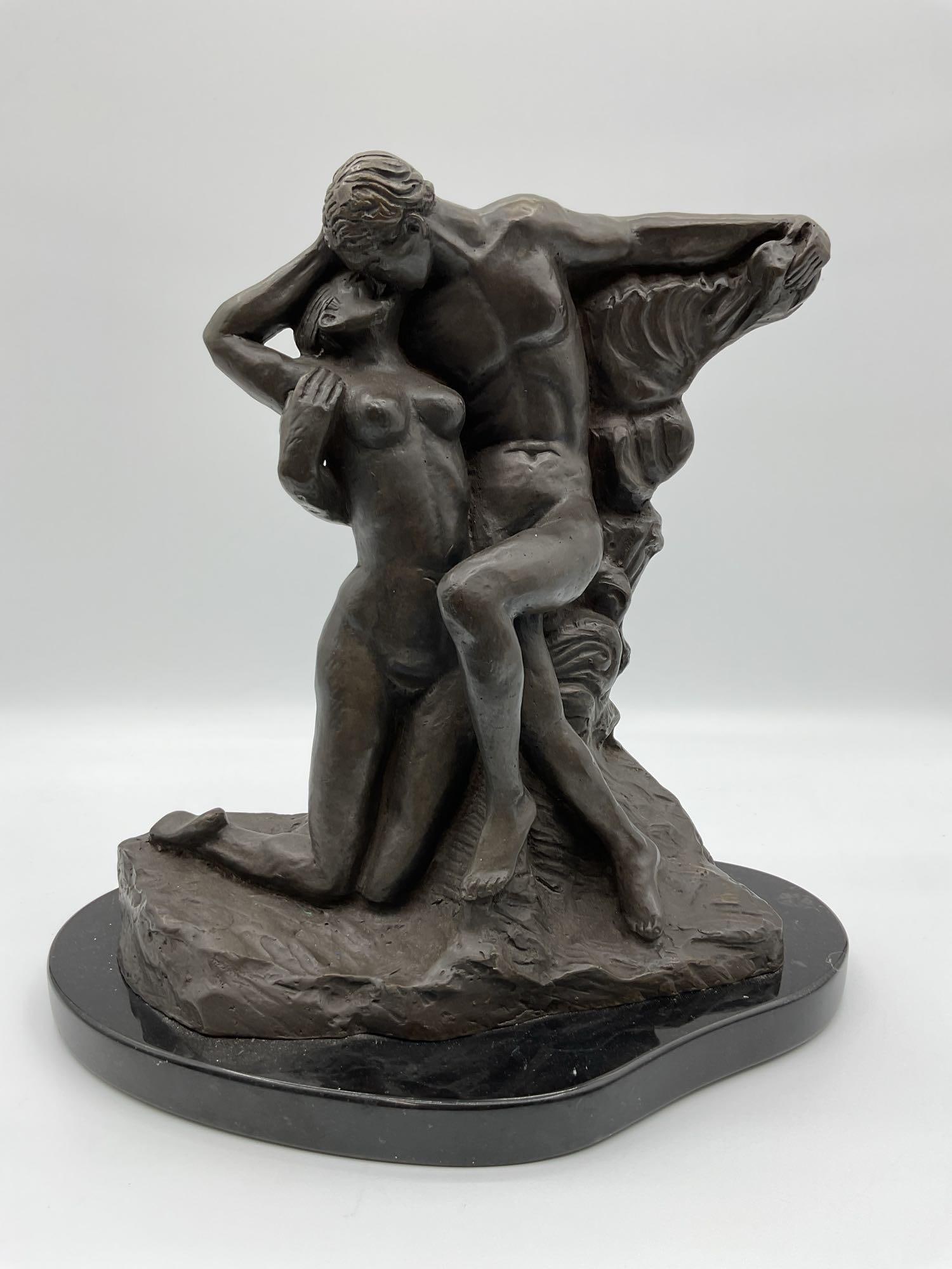 Embrace of Passion Bronze Sculpture: A romantic bronze sculpture depicting a nude couple in a dramatic and intimate pose, with flowing drapery adding dynamic movement. Mounted on a black oval marble base.Dimensions: H16in L15in