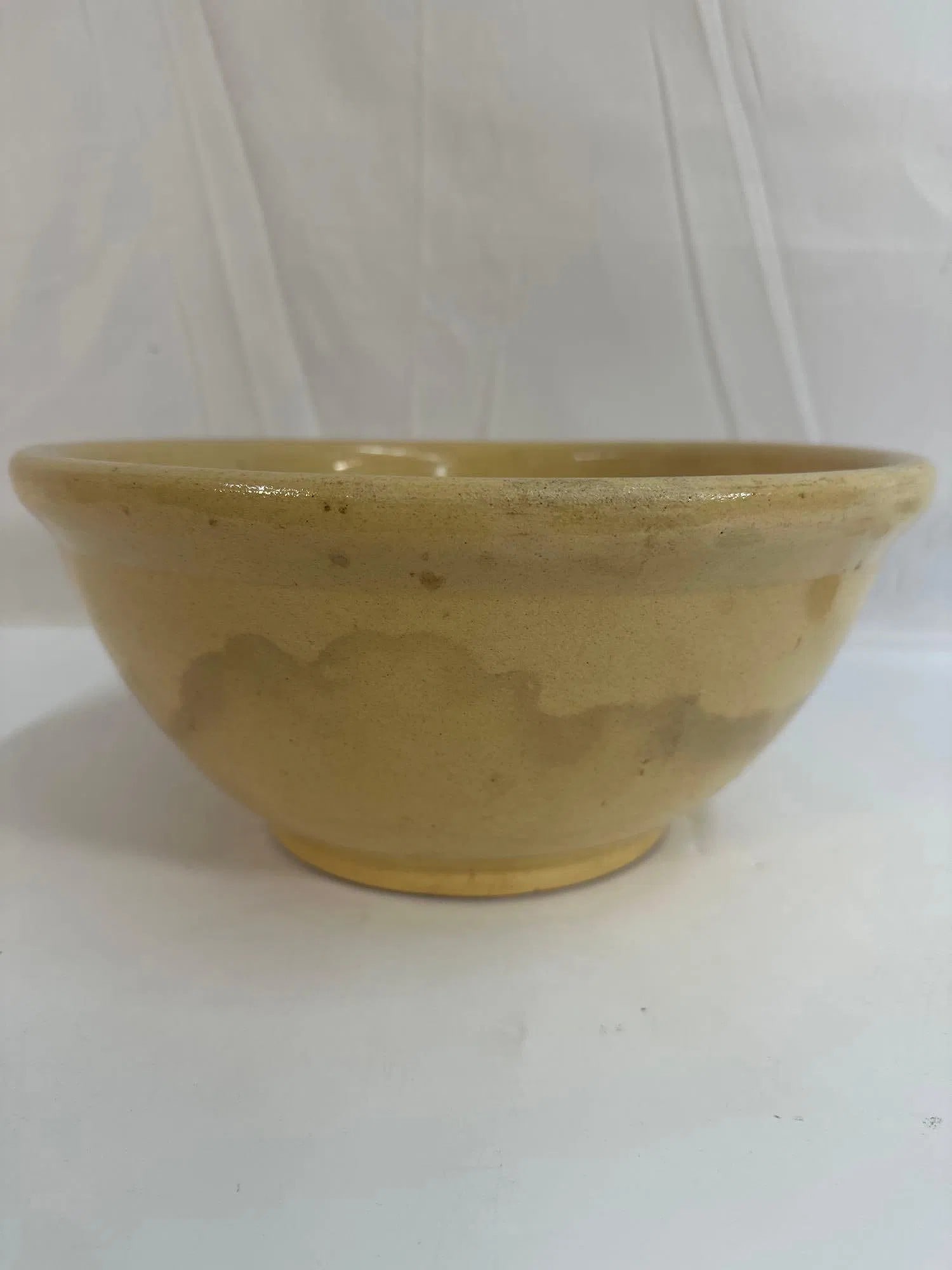 Yellowware Bowl - Box 14: This classic yellowware mixing bowl features a smooth, glossy glaze with subtle decorative banding near the rim. Yellowware was widely produced in the 19th and early 20th centuries and is highly colle