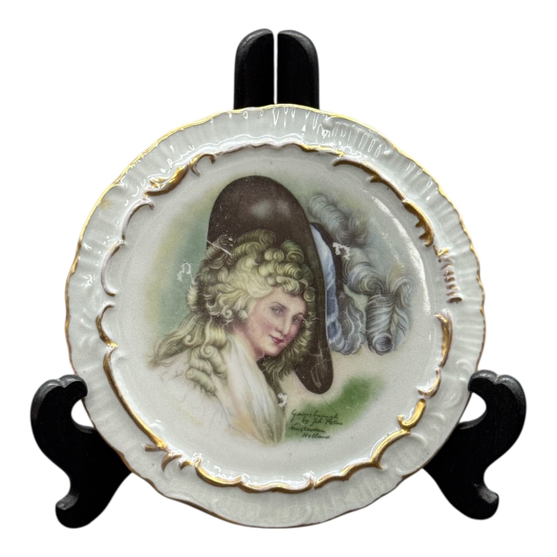 Decorative Porcelain Portrait Plate with Gilt Accents: Decorative porcelain plate featuring a romantic portrait of a young woman wearing a bonnet, accompanied by a dog, rendered in soft pastel tones. The scalloped rim is accented with subtle gilt highligh