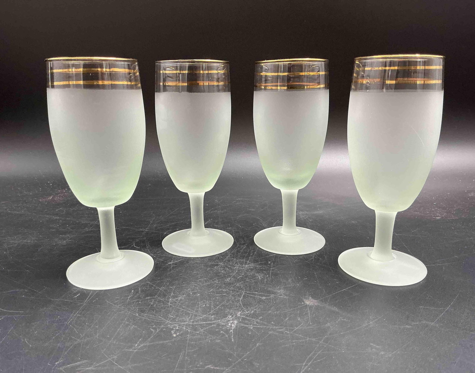 Set of 4 Frosted Stemmed Glasses with Gold Trim: Elegant vintage frosted glass goblets featuring three fine gold bands at the rim. A refined and minimalist mid-century style.Medium: Frosted glass with gold trim