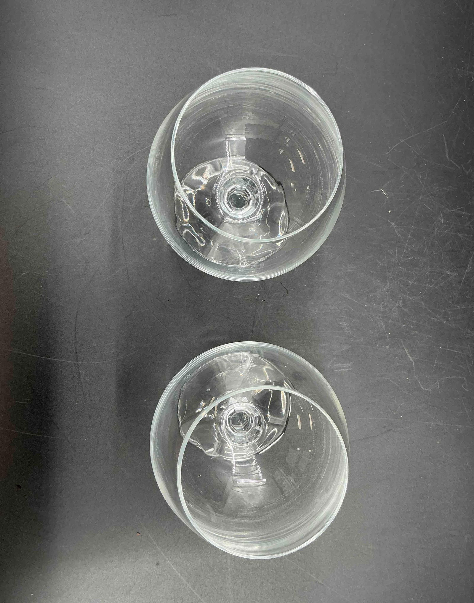 Pair of Clear Crystal Brandy Snifters: Two rounded brandy snifter glasses with wide bowls and short stems, ideal for swirling and enjoying aromatic spirits.Medium: Clear crystal glass