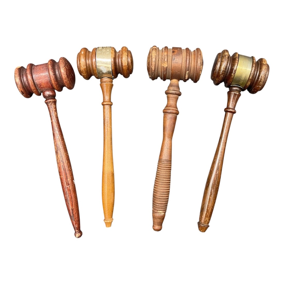 Group of Four Vintage Wooden Auctioneer Gavels: A group of four vintage wooden gavels, each crafted in turned hardwood with varying handle profiles and head forms. The collection showcases different tones and finishes ranging from warm honey to dee