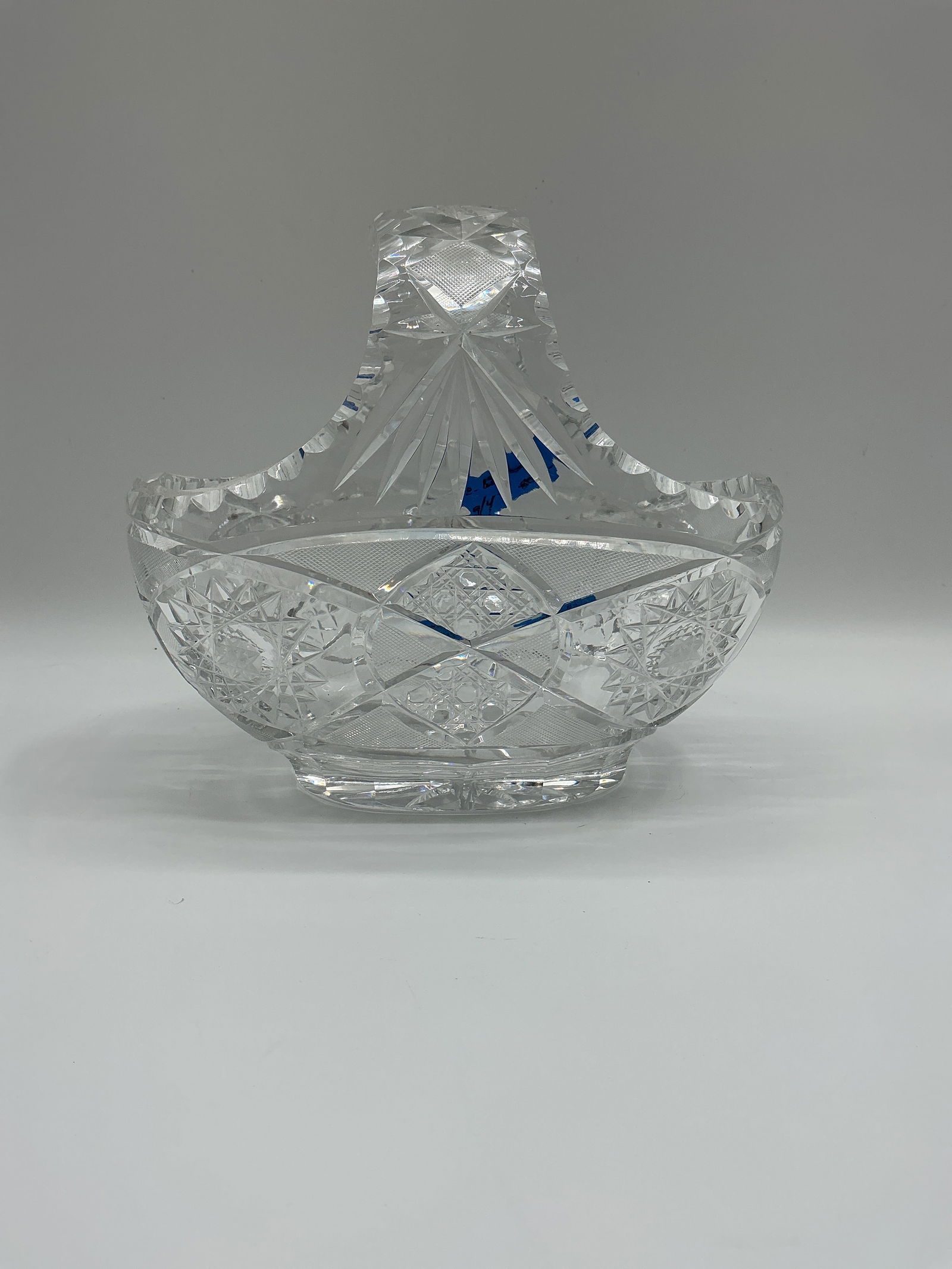 Cut Crystal Basket with Handle: Cut crystal basket featuring a decorative handle and intricate diamond and starburst patterns. These intricate patterns are too time consuming and difficult for modern artesian. A rare opportunity to