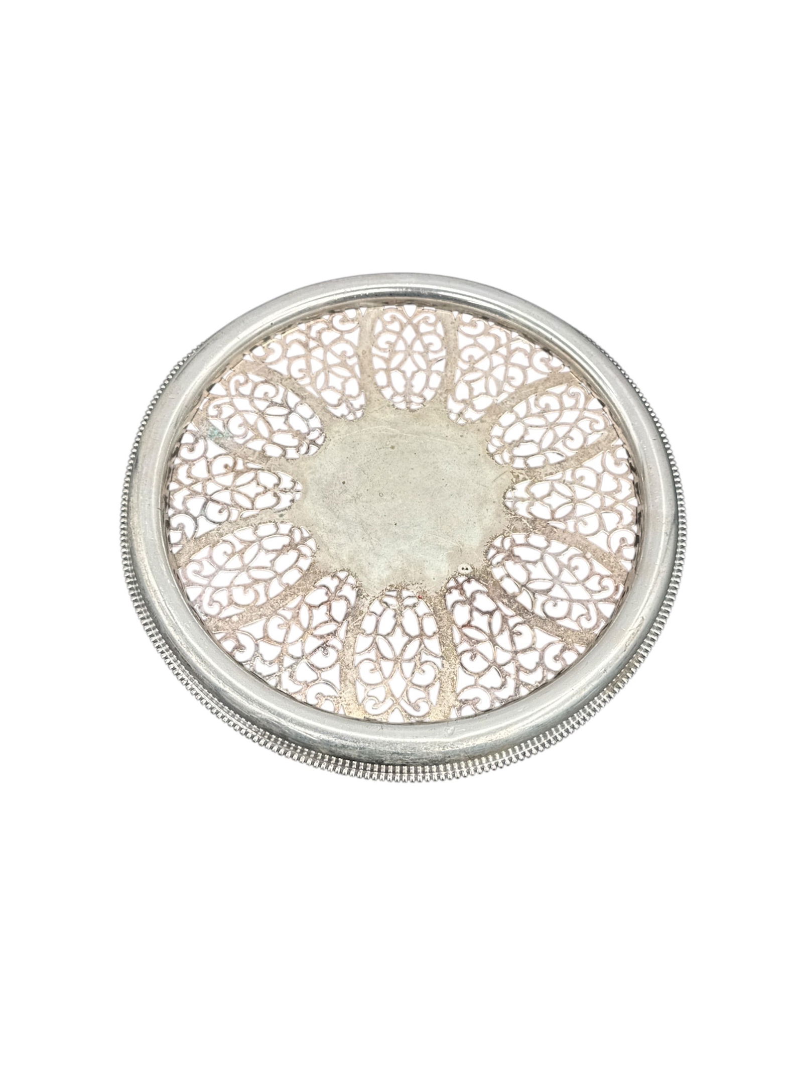 Silver Plate Coaster with Pierced Design: A silver-plated coaster featuring a pierced design. The coaster has a circular form with a decorative border and an openwork pattern in the center. Shows wear consistent with age.
