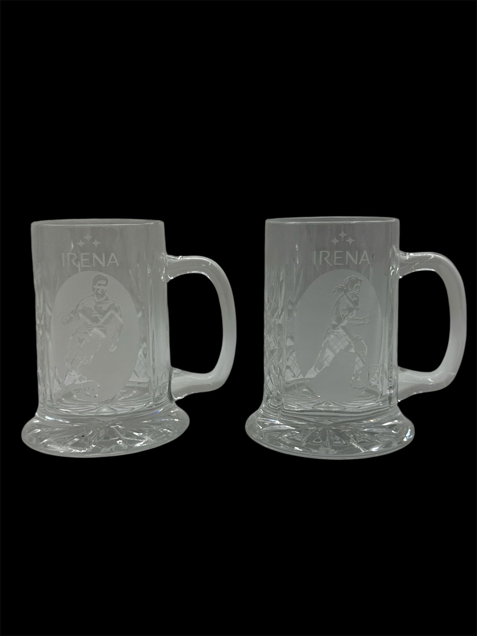 Pair of Frosted Glass Beer Mugs with Figural Design: A pair of frosted glass beer mugs featuring molded figural decoration and raised lettering. Each mug is designed with a sturdy handle and thick base, showcasing an etched-style character motif and