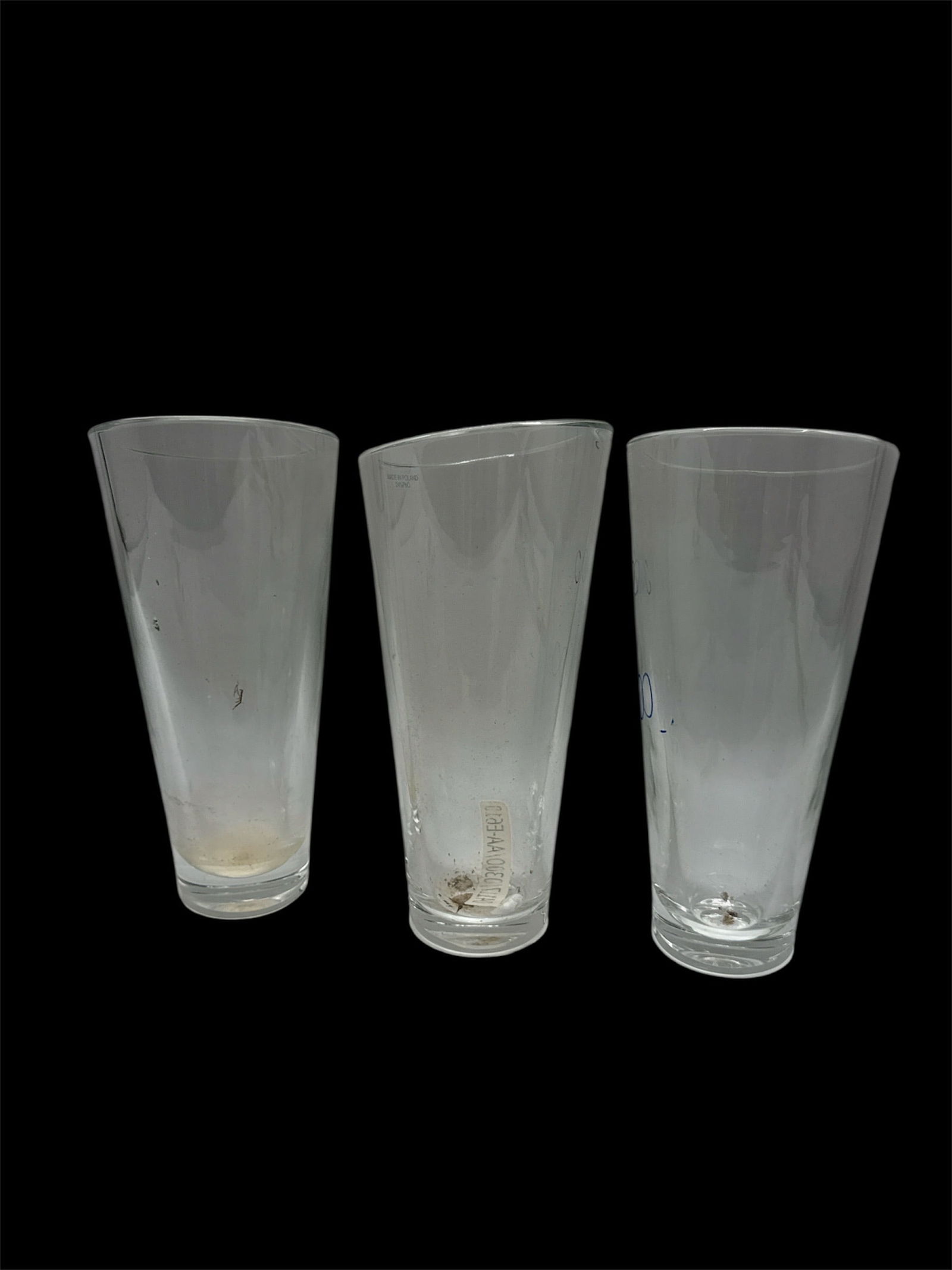 Set of Three Clear Glass Tall Tumblers: A set of three clear glass tall tumblers featuring a simple tapered cylindrical form with thick bases. The clean, minimalist design makes these glasses versatile for use as beverage tumblers, water gl