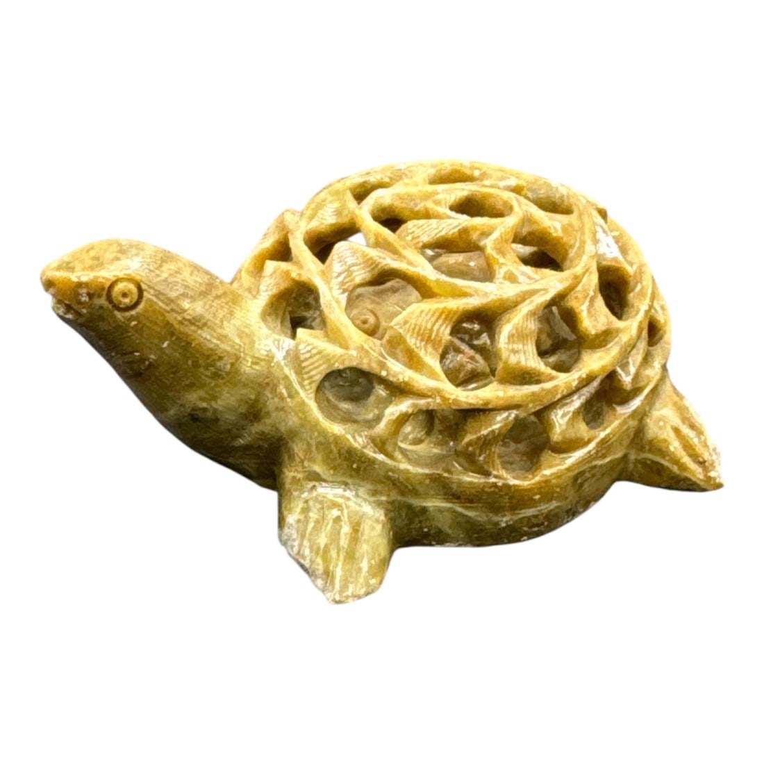 Carved Stone Turtle Figurine: Carved stone figurine depicting a turtle with an intricately carved openwork shell featuring swirling geometric motifs. The figure is rendered in a warm-toned stone with natural veining and texture vi