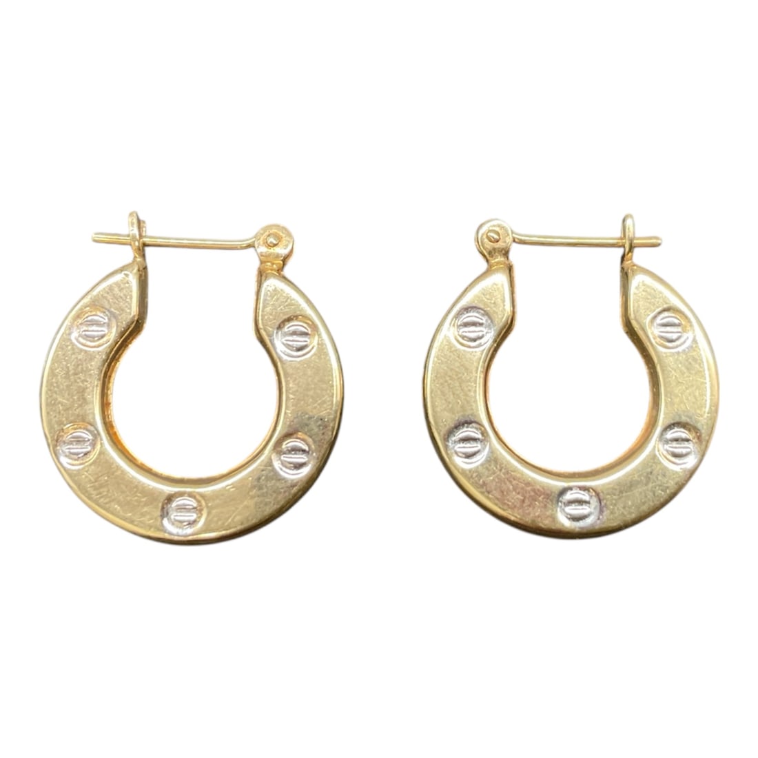 Cartier Style Hoop Earrings Possibly 14K Gold: Pair of Cartier style hoop earrings featuring a bold circular form accented with screw head motif detailing. The earrings display a polished yellow gold appearance with contrasting silver tone screw