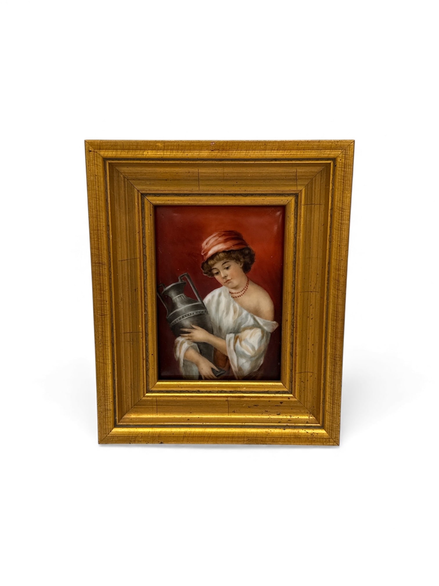 KPM German Porcelain Hand Painted Plaque: Description: Framed portrait painting featuring a young boy in a red hat, holding a top hat. Signed illegibly in the upper right corner. Housed in a gold-tone frame.Dimensions: H:10in W:8in