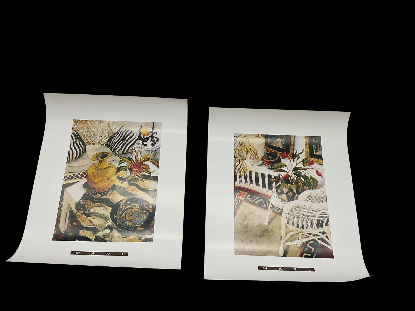 Still Life and Interior Print Set (2): Pair of detailed prints featuring warm, richly textured interior scenes with wicker furniture, florals, and still life arrangements. Sold together as a coordinated set.Medium: Offset lithograph