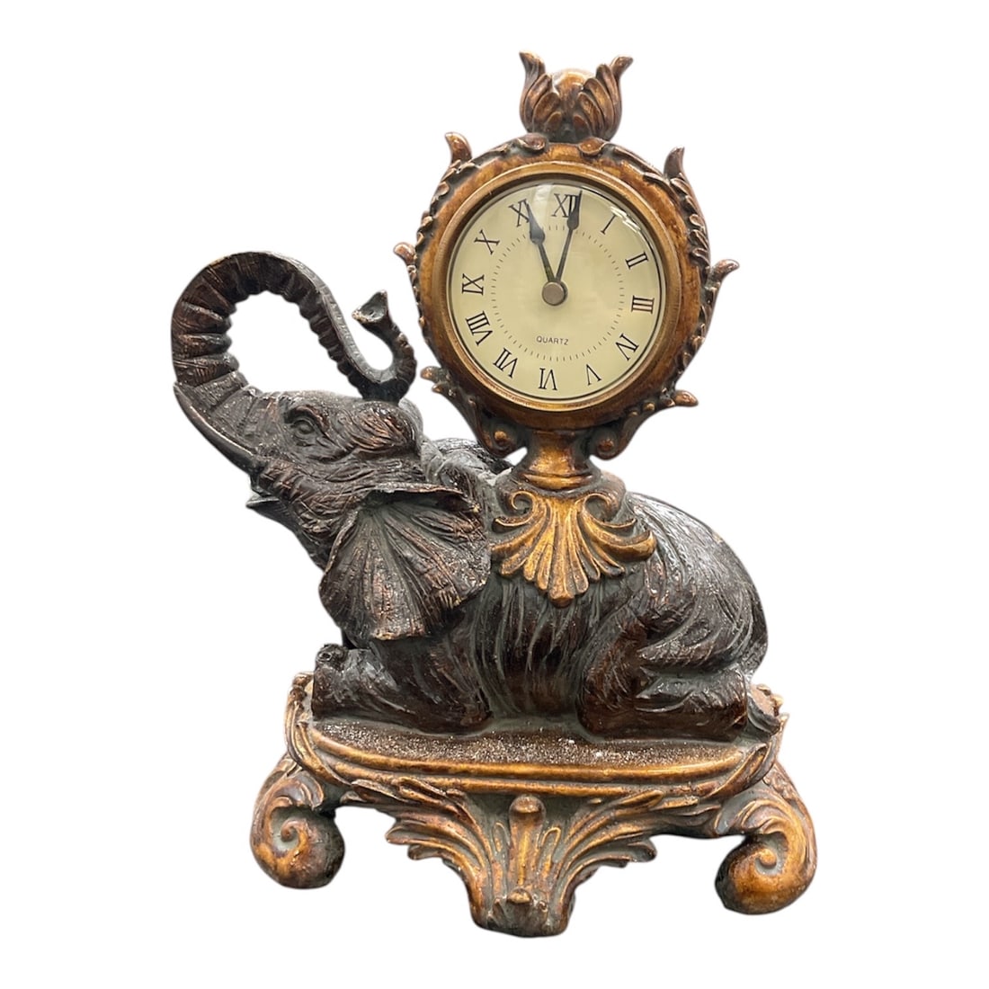Decorative Elephant Figural Mantel Clock: This decorative mantel clock features a sculptural elephant form rendered in a classical, ornate style. The elephant is shown seated with raised trunk, supporting a round clock with Roman numeral