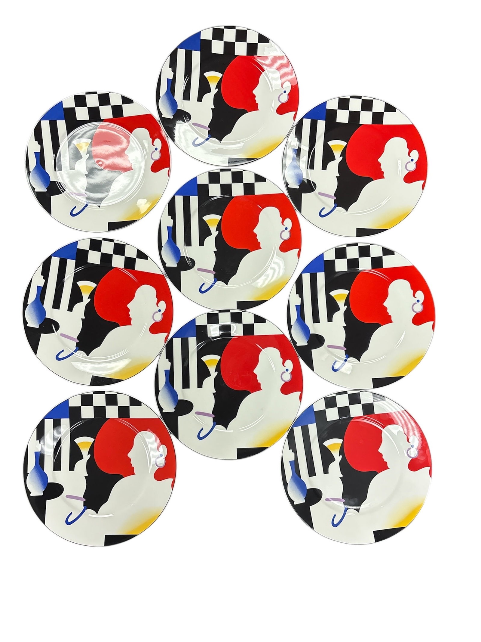Set of 9 Mikasa Maxima Decorative Porcelain Plates: This is a complete set of nine Mikasa Maxima porcelain plates featuring a bold, modern graphic design with stylized figures, checkerboard elements, and strong contrasting colors. The plates showcase M